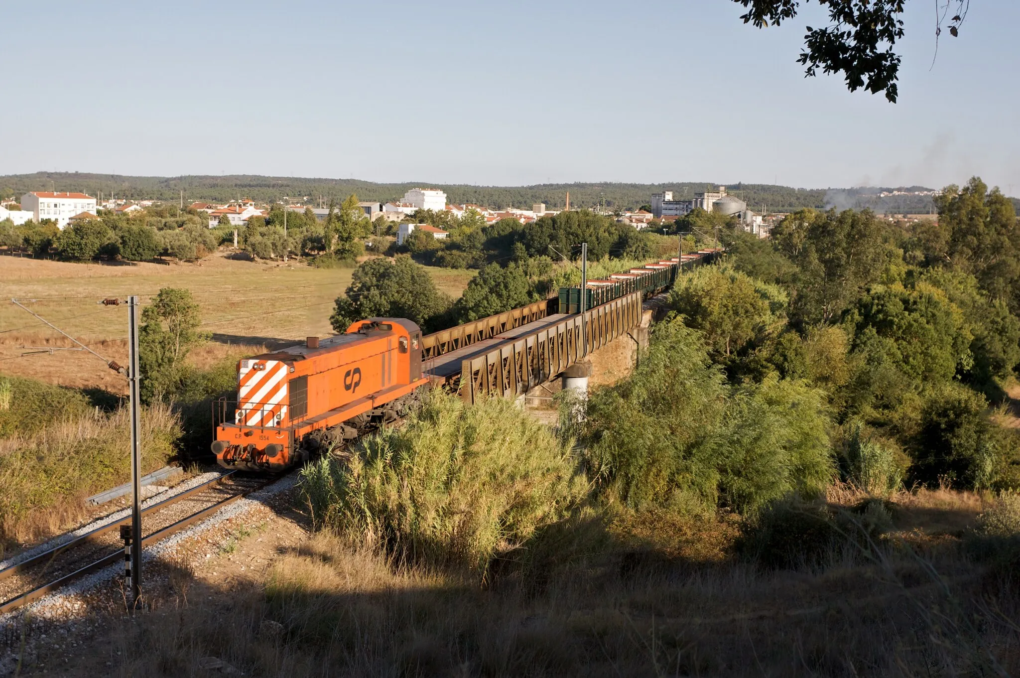 Photo showing: Tipo: Comboio de Distribuição 75530 (transporte de madeira) [Fundão - Entroncamento]
Local: Rossio ao Sul do Tejo [Linha da Beira Baixa, PK 134]
Data e hora: 15 de Setembro de 2009 [18h14]

Material: Locomotiva 1554 + 12 vagões (2 CP Rlps e 10 CP Kbs)