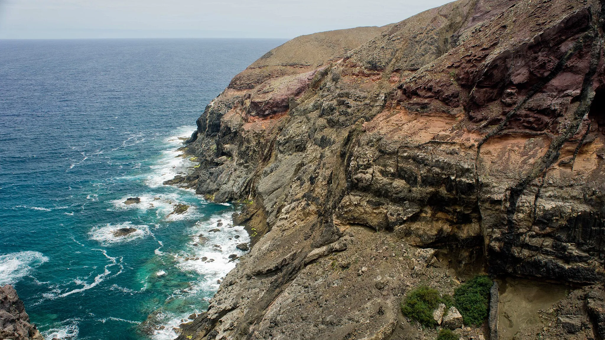 Photo showing: Cliff of volcanic rocks near Ponta da Canaveira on the island of Porto Santo, Madeira.