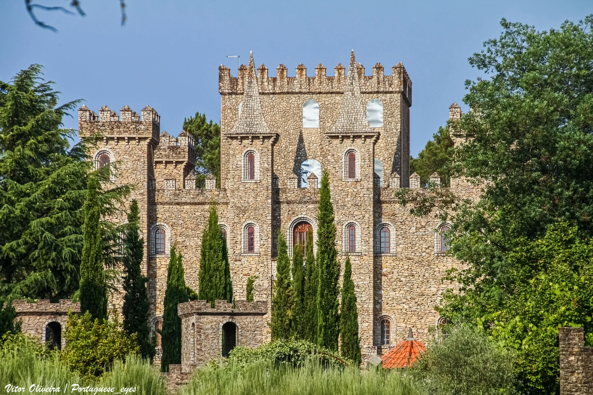 Photo showing: Ao passar na estrada que liga Vila Nova de Paiva a Sernancelhe, encontrará na aldeia de Lamosa um edifício que em tudo parece um castelo. Este edifício está a ser construído graças aos esforços de um só homem, que pedra a pedra o está a erguer, para deleite dos moradores e visitantes que por ali passam.
Este é um velho sonho de Adriano dos Santos, nascido em Leomil. no vizinho concelho de Moimenta da Beira, e que se fixou no Carregal por lá ter casado. Sustenta a família graças ao seu conjunto musical, que financia também a construção do seu castelo.
A edificação do castelo em si começou há mais de doze anos, estando já edificadas as torres e os pináculos. Existe também uma muralha, que cerca o castelo, os jardins e a residência de Adriano e da família.
“Sempre gostei de castelos e dessas coisas assim do tempo medieval”, explica Adriano dos Santos que “sempre quis fazer uma coisa diferente” no terreno.”
Desde sempre que era fascinado por castelos, palácios e casas senhoriais. Colecionava livros e figuras de construções amuralhadas. Daí até construir o castelo dos seus sonhos, foi um pequeno passo.
Hoje, Adriano vive com a família numa casa rodeada de ameias, torreões e uma muralha, num castelo que já se tornou atração turística.  Todo o complexo tem o nome de “Retiro do Sossego”, mas o castelo em si terá o nome de “Castelo do Adriano”. “Há ‘Castelo Rodrigo’, também pode haver ‘Castelo de Adriano’”, explica o proprietário.
As primeiras estruturas foram erigidas há vinte anos, altura em que todos os dias Adriano tinha uma nova ideia. Desenhou-as em papel e escolheu as melhores. Pouco depois, começava a estrutura. O muro com as ameias, torreões e o próprio castelo só foram legalizados quando já estavam de pé. “Se fosse mostrar o projeto à Câmara, aquilo era logo tudo chumbado”, recorda Adriano, que mesmo assim viu várias vezes a obra embargada pelos fiscais municipais. “Não me saíam aqui da porta. Um dia fui à Câmara e falei com um dos vereadores. Nunca mais cá voltaram”, lembra. 
O castelo deverá ser transformado em restaurante, segundo os planos do dono. “É uma coisa diferente, pode ser que dê resultado”, vaticina Adriano Santos, que está a equacionar candidatar o projeto a fundos estruturais. “Ainda vai ser preciso muito dinheiro para acabar e montar tudo”, refere.
No rés-do-chão, deverá existir um espaço mais virado para os jovens, com som ambiente e ecrã plasma. O primeiro andar albergará a sala do restaurante, num ambiente mais formal. O piso de cima, junto à torre de menagem, servirá de esplanada.
Todo o complexo tem sido construído por Adriano Santos e pelos dois filhos, um dos quais se casou lá, num banquete que dizem ter sido inesquecível. Até agora, Adriano terá gasto mais de 350 000 euros na construção, valor que inclui o custo do seu trabalho e dos seus filhos. 
O castelo é alvo dos olhares de curiosos, especialmente desde que tomou a ganhar forma. “Às vezes, é uma romaria à porta. Há dias em que digo que o dono não está e lá se vão embora. Só assim é que consigo ter paz para acabar a obra”.
Ao longo destes 20 anos, houve ocasiões de ânimo e de desânimo, segundo Adriano. “Isto tem ido aos poucos. Umas vezes depressa de mais, outras devagar. Às vezes, desanimo, mas é sempre por pouco tempo”, lembra.
O complexo encontra-se a 4 quilómetros do Santuário da Lapa, sendo o castelo visível da estrada de acesso à Lapa. Assim, “Nos dias de romaria, muita gente faz um desvio e passa por aqui para o admirar”, conta Adriano.

www.vortexmag.net/castelo-do-adriano/