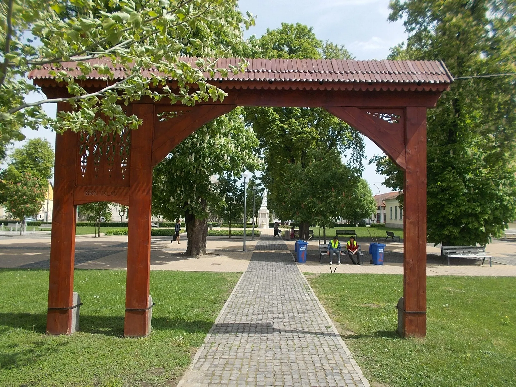 Photo showing: : Ciumani (Harghita County) gate by Ernő Csata and Attila Jánosi Borsos. Ciumani is sister town of Heves. - Hősök tere, Heves, Heves County, Hungary.