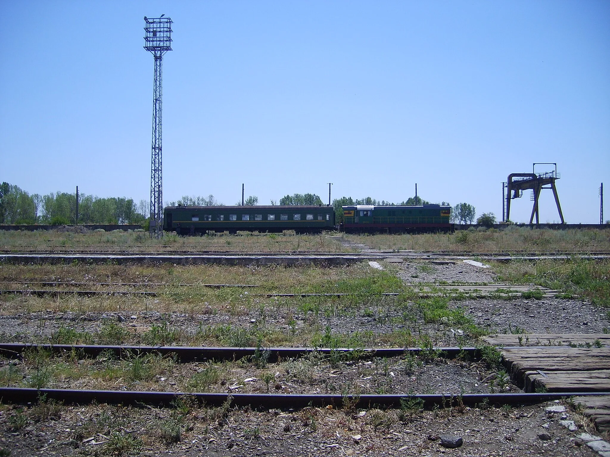 Photo showing: Train station in Fălciu, Vaslui, Romania. A former busy border crossing with the USSR (change of gauge); at time of our visit, it was largely empty, with most technology disfunctional. The passenger train in the back belongs to Moldovan railways and runs several times a week on broad-gauge rails across the border to Prut, Moldova.