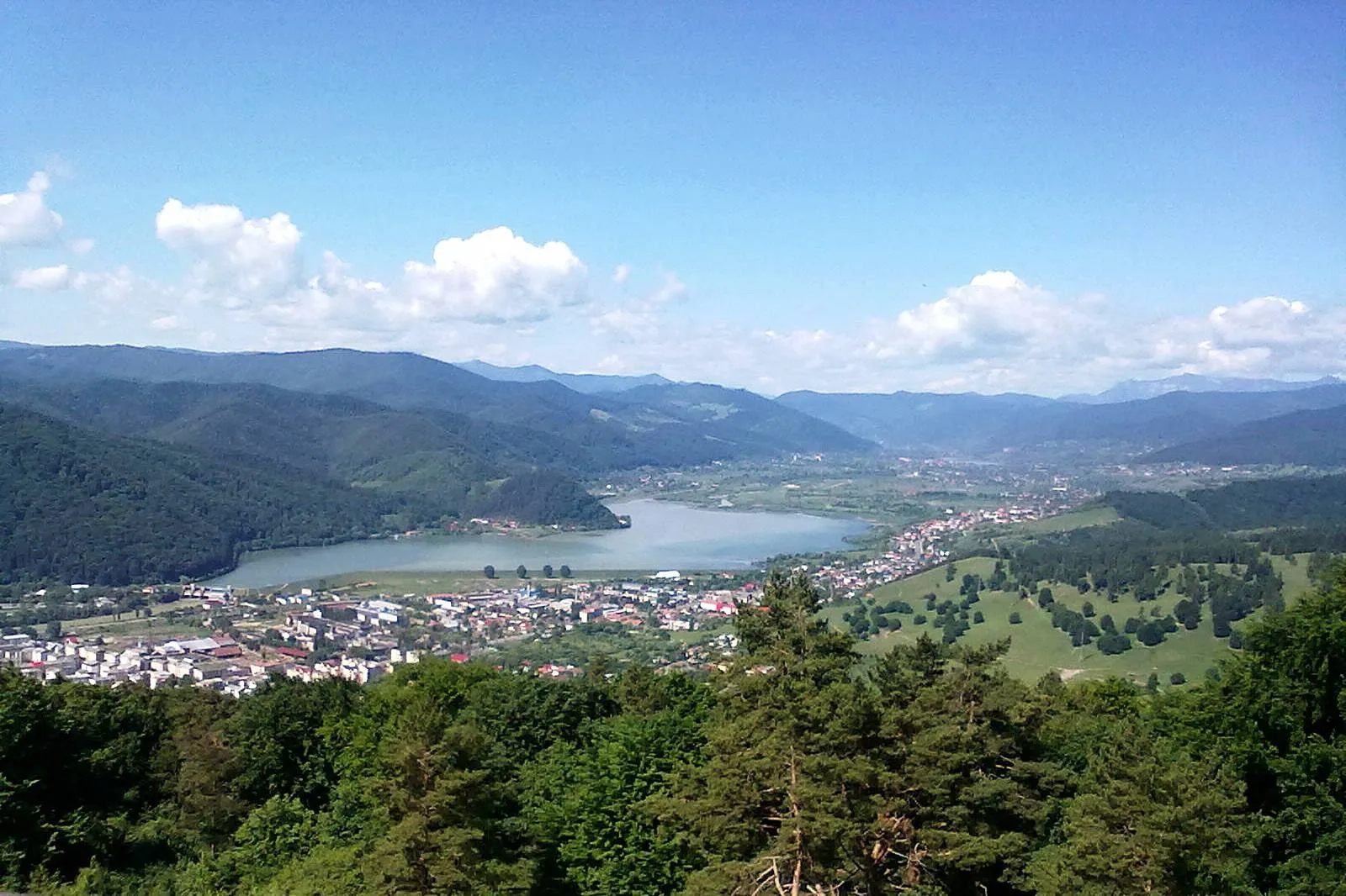 Photo showing: Situl arheologic de la Piatra Neamț, punct „Dealul Bâtca Doamnei”
La iesirea din Piatra Neamt spre Bicaz, pintenul Batca Doamnei (457 m) se oglindeste in luciul lacului de acumulare cu acelasi nume. Pe platoul de pe Batca Doamnei se afla ruinele unei cetatii dacice, cel mai vechi vestigiu istoric din Piatra Neamt si una dintre cele mai interesante si mai comentate fortificatii antice din Moldova.
Vestigiile arheologice de pe Batca Doamnei au fost descoperite de cercetatorul Constantin Matasa, fondatorul Muzeului de Istorie din Piatra Neamt, in urma unor cercetari facute in 1928. Potrivit unor aprecieri, cetatea dacica de pe Batca Doamnei ar fi una si aceesi cu Petrodava - pomenita in una dintre lucrarile lui Ptolemeu; cercetari asupra sitului arheologic au fost facute in anii 1928, 1957 si 1962 - 1985 fara a avea insa amploarea pe care ar impune-o un asemenea obiectiv.
Se estimeaza ca Cetatea a fost ridicata spre sfarsitul secolului al II-lea si inceputul secolului I i.e.n. Sapaturile arheologice au scos la iveala urme din epoca neolitica si din epoca bronzului, cele mai reprezentative vestigii de viata pe inaltimea Batca Doamnei fiind din epoca dacica; locul unde a fost fortificatia dacica are forma unui patrulater neregulat cu laturile de 170 m si 110 m. Piatra din care a fost construita cetatea provine din muntii din apropiere si prezinta urme de prelucrare cu dalta.
Cetatea a fost ridicata in doua etape: prima, datand din secolul al II-lea i.e.n., era fortificata cu palisada ; se crede ca au existat ziduri de piatra si in prima faza (probabil apartinand unui turn care strajuia intrarea in cetate), in cea de a doua faza a constructiei, care a fost estimata in secolul I e.n., palisada a fost desfiintata in intregime, peste ea construindu-se un zid puternic de piatra cu o grosime estimata de 3,50 m.
S-au pastrat fragmente de zid inalt pana la 1,30 m. S-a constatat ca pietrele cazute sau cele care se mai pastrau in zid purtau urmele unui puternic incendiu, concluzia fiind ca zidul a avut o suprastructura de lemn.
In partea de sud, unde era intrarea in cetate, ca si in partea de vest, incinta de piatra a zidurilor a primit inca o intaritura formata dintr-o palisada cu o lungime de 240 m. Aceasta se poate remarca cu usurinta si acum pe teren, deoarece se prezinta sub forma unui val de pamant; in spatele acestei palisade s-a descoperit un drum (un fel de drum de rond) folosit de aparatorii cetatii.
La poalele inaltimii, la o anumita distanta de cetate, s-au gasit trei santuri late si adanci sapate in stanca. Dupa unii cercetatori ele ar fi fost sapate de romanii care au asediat cetatea in primavara anului 106; inaintea acestor santuri se observa destul de bine urmele drumului antic care ducea la fortificatie. Dupa unele ipoteze, ultimele rezistente impotriva romanilor au fost cele ale dacilor de la rasarit de Carpati, razboiul incheindu-se cu cucerirea cetatii de la Batca Doamnei si supunerea dacilor din aceasta parte a tarii la inceputul anului 106.
In timpul sapaturilor arheologice din 1961, a fost descoperit un sanctuar, in partea de sud a cetatii, format din patru „tamburi" de forma rotunda, asezati la distante egale; in 1962 s-a descoperit cel de-al doilea sanctuar, format din patru aliniamente de tamburi. Aceste sanctuare sunt intru totul asemanatoare cu cele din Muntii Orastiei.
Ceramica este asemanatoare cu cea descoperita in cetatile din Muntii Orastiei, atat in ce priveste maniera confectionarii, cat si decorarea. Vasele de lut ars sunt de doua categorii: lucrate cu mana dintr-o pasta rosie sau neagra, poroasa si mai putin finisata si vase lucrate la roata dintr-o pasta mai fina, din lut de buna calitate, de culoare cenusie, rosie sau cafenie. Din aceasta categorie se remarca fructierele, canile cu o singura toarta, castroanele, strachinile, bolurile, vasele de provizii. Dintre cele lucrate cu mana, se remarca renumitele cesti dacice - vase cu doua torti, cu gura larg evazata.
De la cetatea dacica au fost scoase la iveala un numar mare de obiecte metalice (fiare de plug de tip dacic, seceri, coase, dalti, tesle de mana, cutite, varfuri de lance si de sageata, vergi, pinteni, cuie, crampoane, fibule, brose, ace, inele), obiecte de os (manere de cutit obtinute din coarne de animale), de piatra (rasnite de forma tronconica, formate din doua bucati, apartinind tipului dacic).
Ultima faza de locuire pe Batca Doamnei este din epoca feudala, prin secolele XII—XIII. Pe ruinele cetatii dacice a aparut o asezare militara, probabil aparata printr-o intaritura de lemn. Asezarea feudala a avut mult de suferit, probabil de pe urma navalirii tatarilor in anul 1241, cand, se crede ca a si disparut.

Cu toate ca resturile stravechilor constructii, nu prezinta spectaculozitatea altor situri arheologice, fiind vizibile doar resturi ale vechilor constructii, lipsite de proportii monumentale, o drumetie pana pe platoul cetatii poate fi o experienta placuta. De pe culmea Batca Doamnei se dezvaluie o priveliste minunata asupra lacului de acumulare, a orasului Piatra Neamt cat si a culmilor muntoase din preajma.