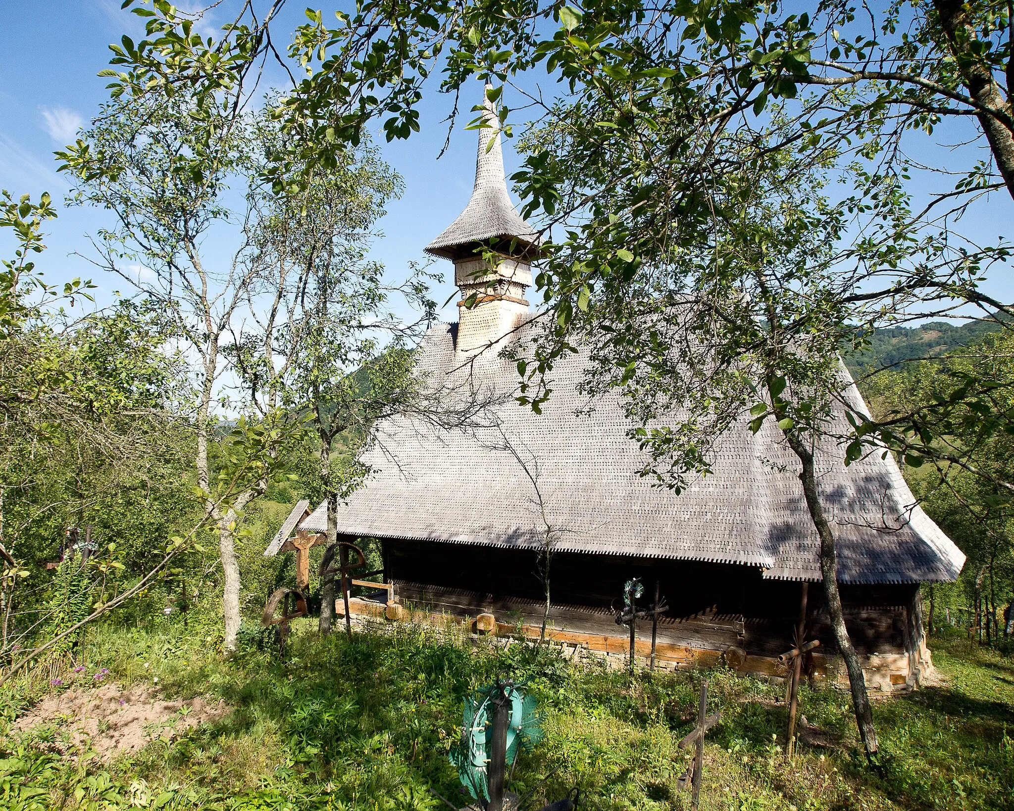 Photo showing: This is the old church "Cuvioasa Paraschiva", constructed entirely of wood and beautifully crafted. It is 400 years old and is not currently used for ceremonies, instead villagers are using the new church, 50 meters, downhill on the slopes. However there are still burial graves around and is impressive by its solidity of construction and not at last the beauty of its location.