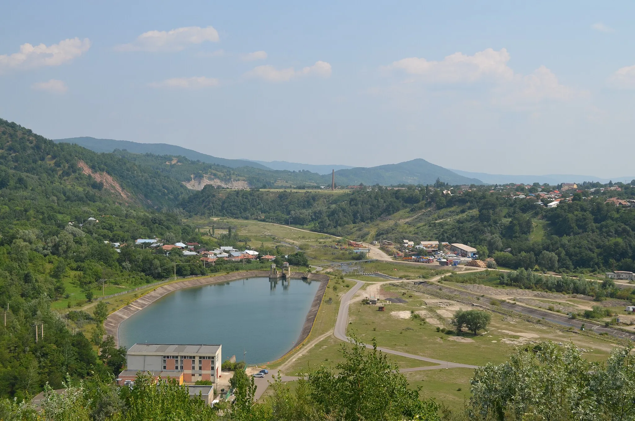 Photo showing: The hydroelectric power station and the evacuation lake, at Măneciu, Prahova, Romania (seen from the dam) To the left: Chiciureni village; Top-right: part of Măneciu
