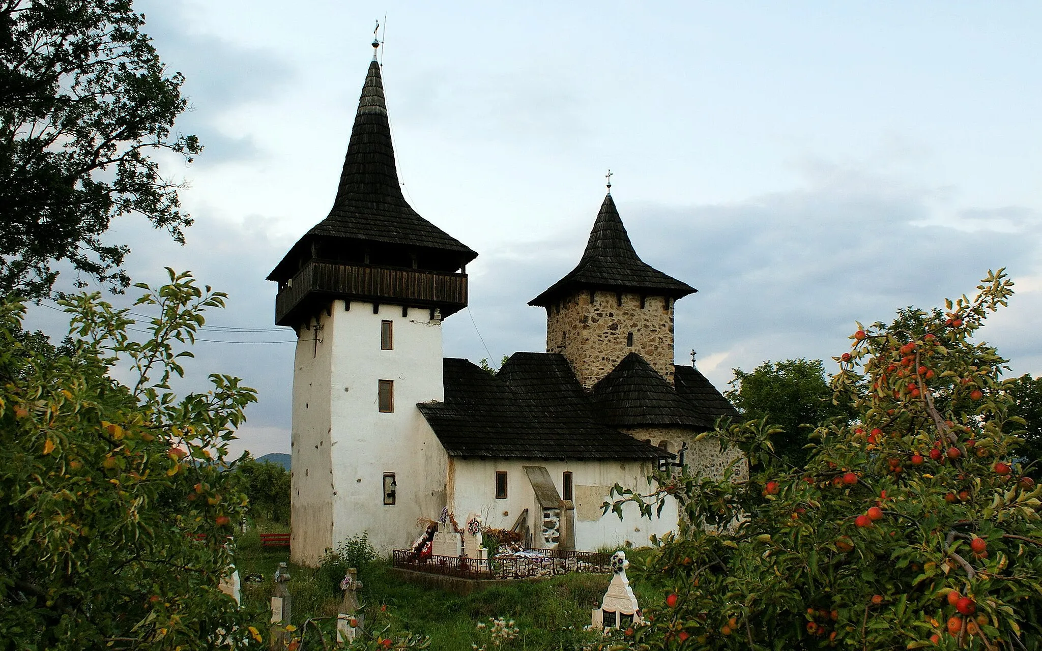 Photo showing: Its distinctive architecture (odd both because it still has a stone part and cause it has two towers) is due to its construction in more steps, each architect contributing to the look it has today. The stone part still has original paintings from the XIVth (notably the Final Judgement scene humorously depicting 30 sins) and XVIIIth centuries(in 1765 empress Maria Theresa of Austria ordered its renovation).