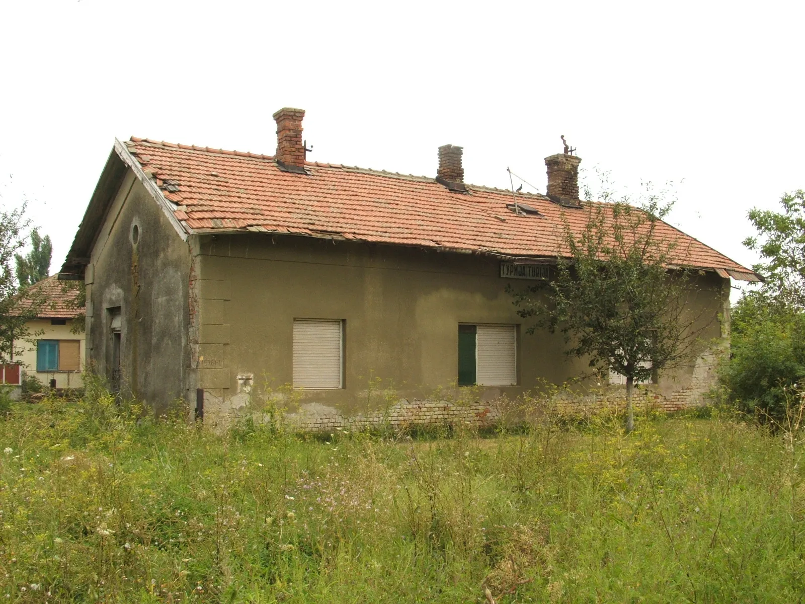 Photo showing: Turja egykori vasútállomása (vágányok felőli oldal). A vágányok fellelhetőek a gazban.