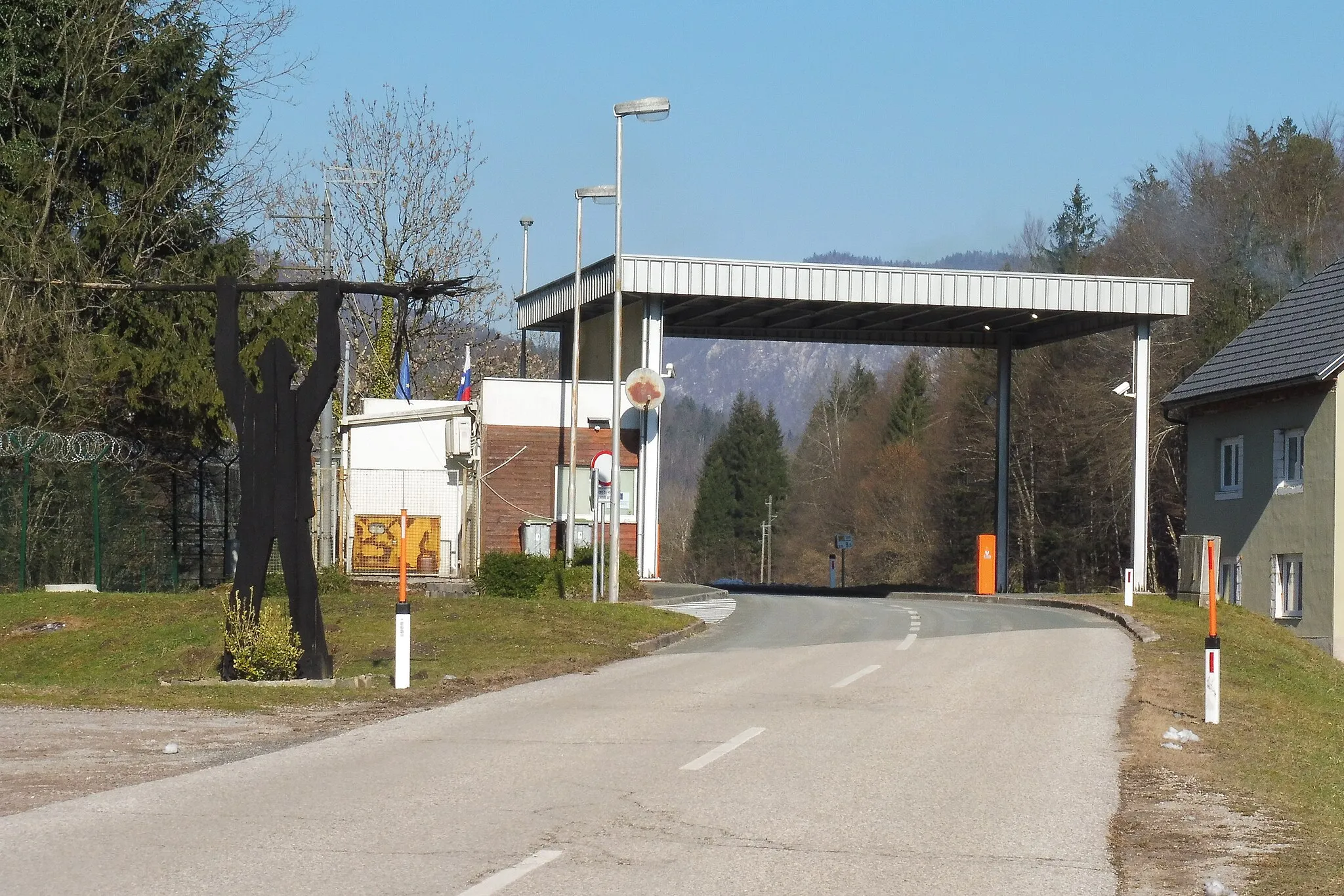 Photo showing: Border crossing for local border traffic Osilnica (Slovenia)/Zamost (Croatia), a month after the abolishment of border control. Passengers entering the municipality of Osilnica are greeted by a wooden Peter Klepec.