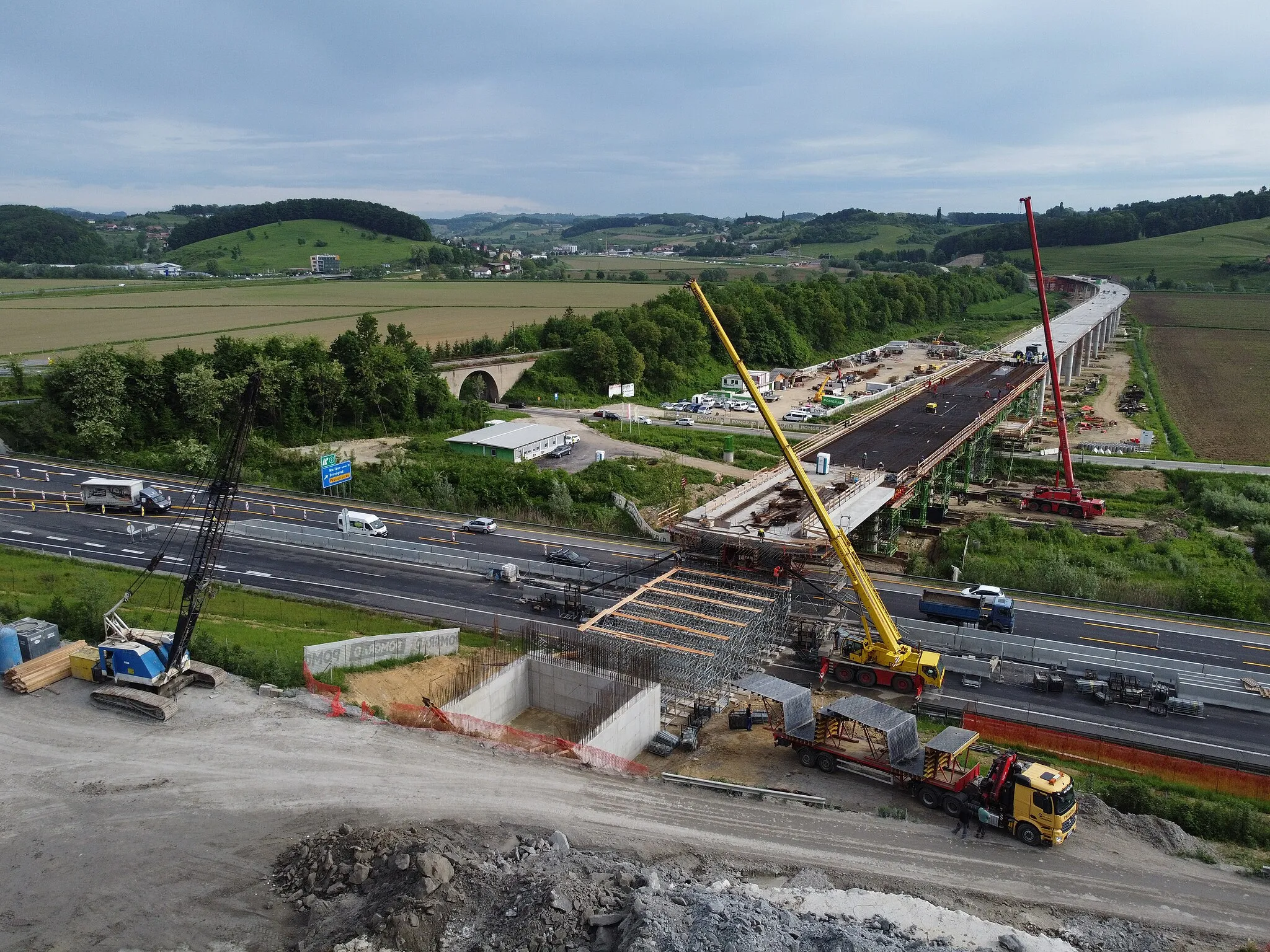 Photo showing: The new Pesnica viaduct will be a relatively low, 912.6-meter-long double-track railway viaduct. It is designed as a series of frame structures connected into an integral structure without bearings. This design concept allows the implementation of a continuous welded rail track (CWR) without expansion joints, with great advantages in terms of traffic safety, economy, sustainability and noise emissions. The new line is planned to open to traffic in mid-2023.