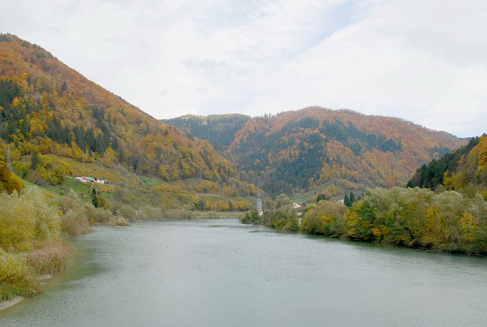 Photo showing: Drautal in Slowenien von der Brücke Brezno - Podvelka Richtung Osten. Die Häuser im Mittelgrund links stehen bei der Mündung des Potočnikov potok (Pototschnigbach), der Graben vor dem Berg im Hintergrund ist der Javniški graben (sic! Graben als Fremdwort, siehe eigenes Bild zur Straßenbrücke dort, auch die Landkarten verwenden die Abkürung „gr“). Dieses Gebiet gehört zur ehemaligen Gemeinde (später nur mehr Katastralgemeinde) Jaunegg zwischen Brezno und Ozbalt, nicht bereits zu Ozbalt (die Bildbezeichnung ist in diesem Punkt fehlerhaft)