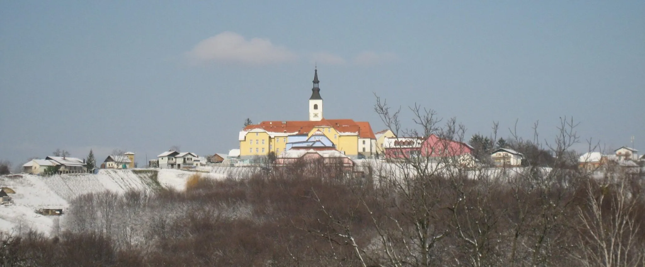 Photo showing: The focus of the picture, Saint Urban's Church (the spire and white nave to the right), is in the settlement of Destrnik. The yellow building in front of the church and the houses and fields in the foreground are in the adjacent settlement of Janežovski Vrh.

photo:Ziga 07:16, 30 January 2007 (UTC)