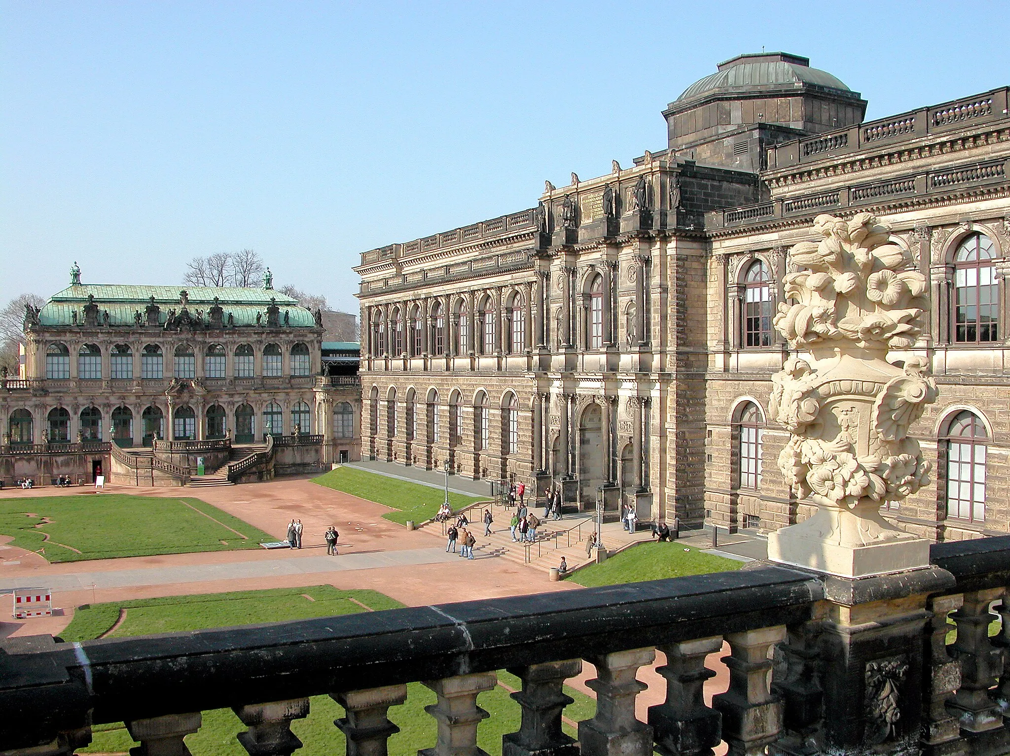 Photo showing: 25.03.2007   01067  Dresden-Altstadt: Dresdner Zwinger. Blick in den Zwingerhof zum Semperbau mit der Gemäldegalerie (GMP: 51.053306,13.734754), errichtet 1847-1854 von Gottfried Semper im Stil der italienischen Hochrenaissance. Bauplastik von Ernst Rietschel und Ernst Julius Hähnel. In der ursprünglichen Konzeption des Kurfürsten Friedrich August I. ("August der Starke") war der Zwinger als Vorhof eines neuen Schlosses vorgesehen, das den Platz bis zur Elbe (nach rehcts) einnehmen sollte; daher blieb der Zwinger zur Elbseite hin zunächst unbebaut. Die Planungen zu einem Schlossneubau wurden nach dessen Tod aufgegeben und mit der Abkehr vom Barock verlor der Zwinger zunächst an Bedeutung. Erst über ein Jahrhundert später schloss ihn der Architekt Gottfried Semper mit der Sempergalerie zur Elbe hin ab.                                                [DSCN21527.TIF]20070325060DR.JPG(c)Blobelt