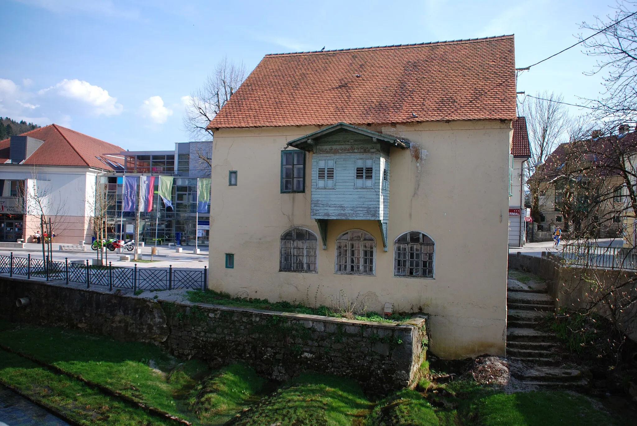 Photo showing: Sitarjeva hiša (med prebivalci kraja poznana tudi kot stara lekarna) - trška hiša z lesenim prizidkom ob potoku v Dolenjskih toplicah, Slovenija