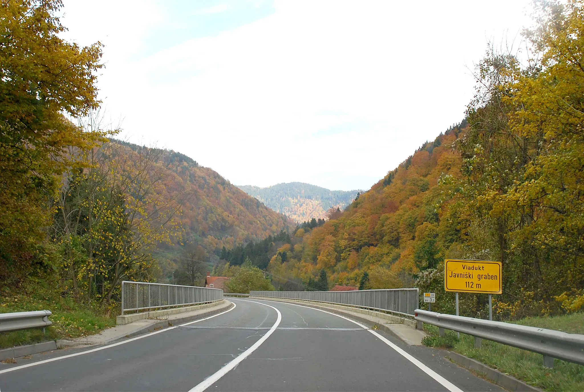 Photo showing: Drautal in Slowenien zwischen Brezno und Ožbalt im Gebiet von Javnik (ehemalige Gemeinde Jaunegg): Straßenbrücke der Mariborska cesta/Marburger Straße über den Javniški graben (sic! Graben als Fremdwort im Namen, auch die Landkarten verwenden die Abkürung „gr“).