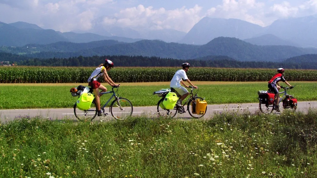 Photo showing: Three male cyclists wearing helmets during a summer bicycle tour in rural Slovenia near Luže.