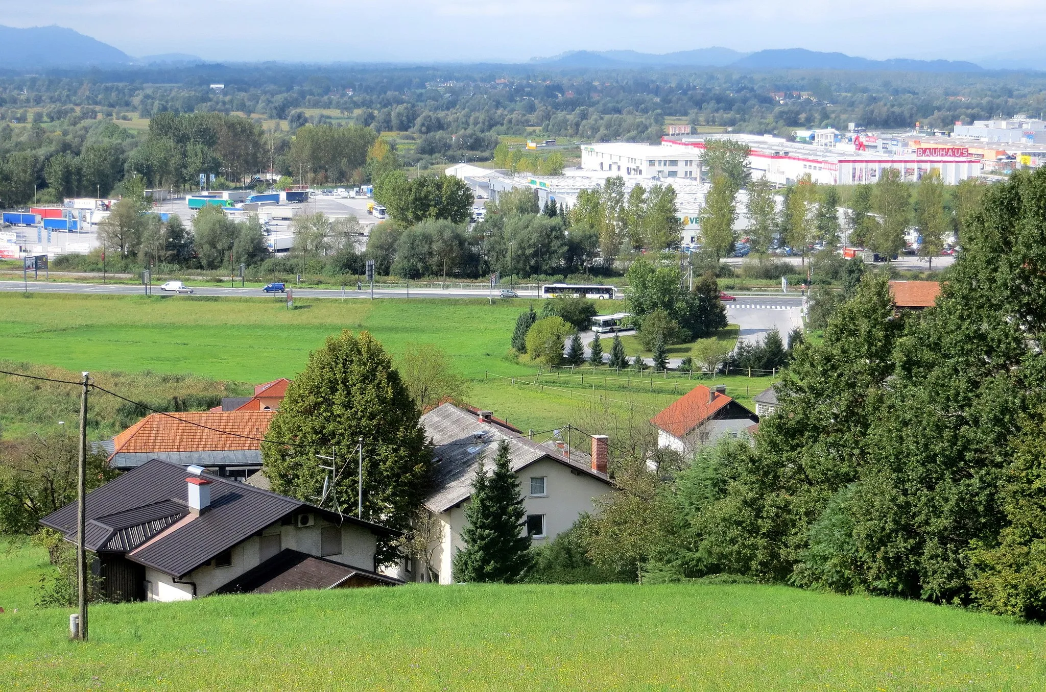 Photo showing: Old part of Rudnik, City Municipality of Ljubljana, Slovenia (foreground) and new shopping center (background)