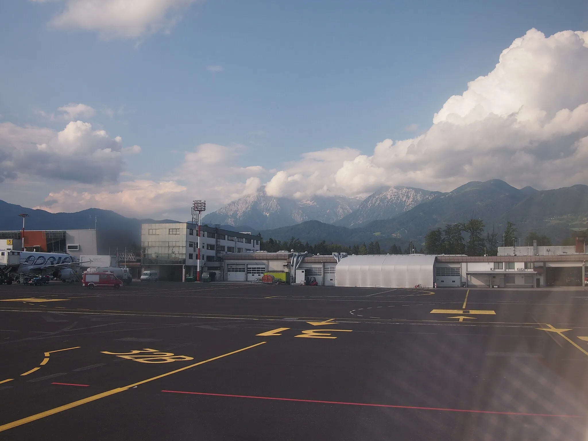 Photo showing: June 2014. View from Adria Airways Canadair CRJ900, reg. S5-AAU, across the apron of Ljubljana Jože Pučnik Airport (Brnik Airport).