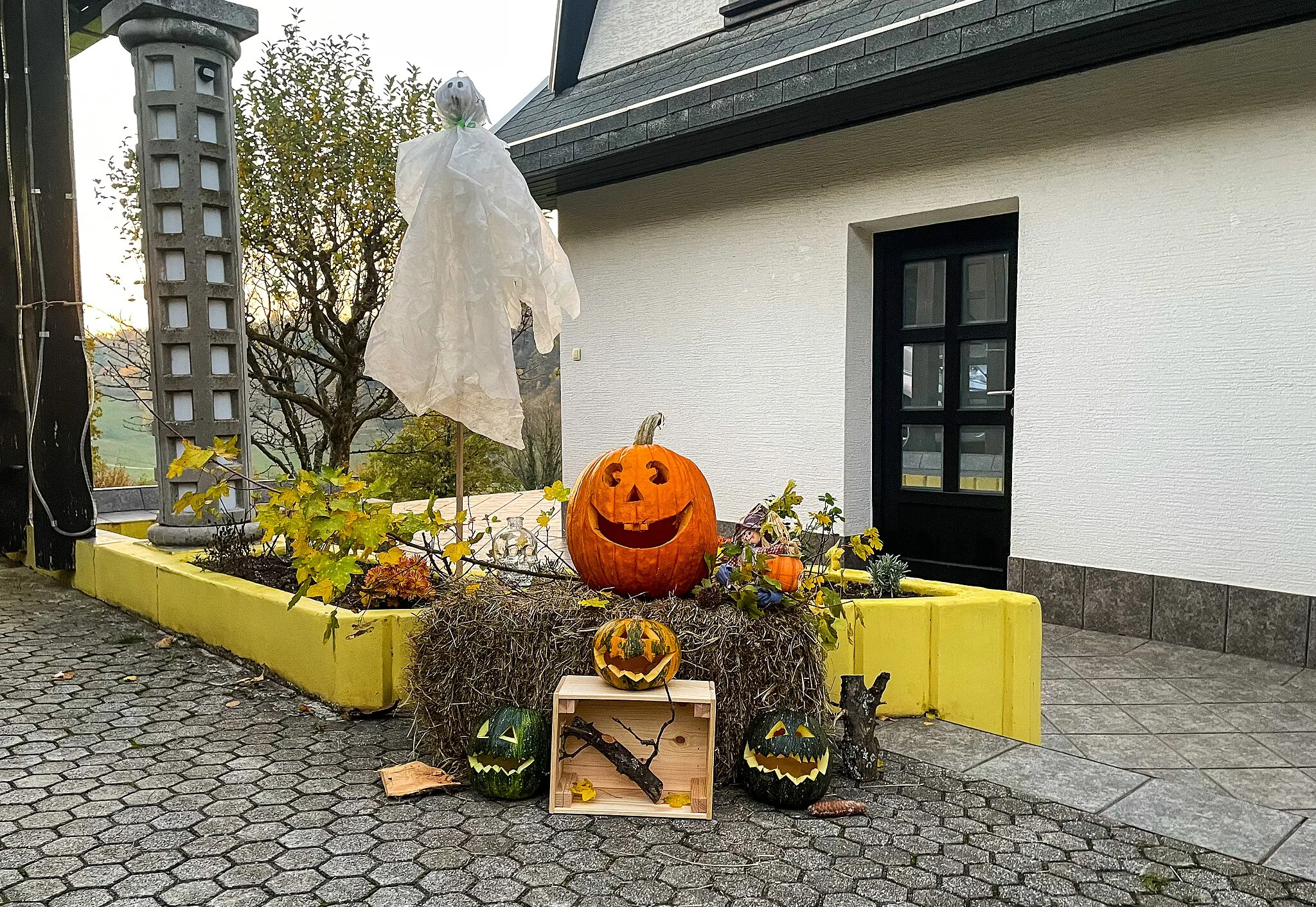 Photo showing: Carved pumpkins near black house door, side view