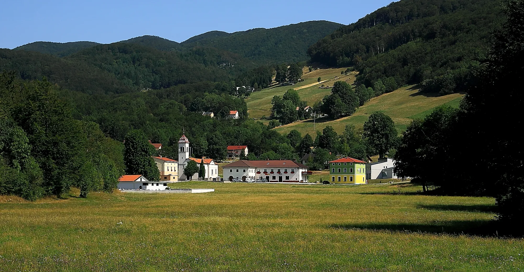 Photo showing: Otlica, pogled preko travnika na vas Otlica.