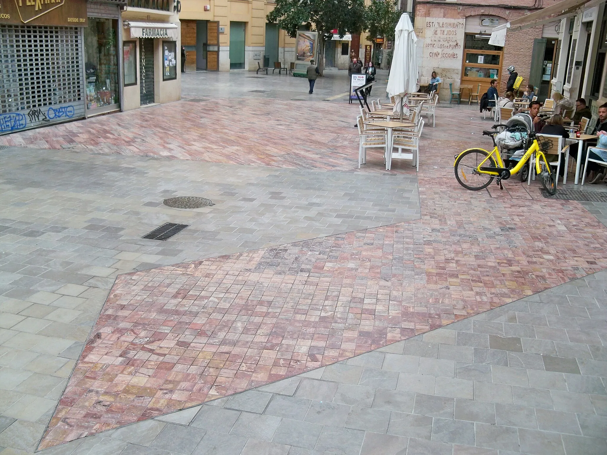 Photo showing: Vista de la calle Puerta Nueva, en Málaga, España, donde se aprecia el recorrido de la muralla medieval de Málaga marcado sobre el pavimento de la calle con mármol travertino rojo sobre la proyección en planta de la traza de la muralla.