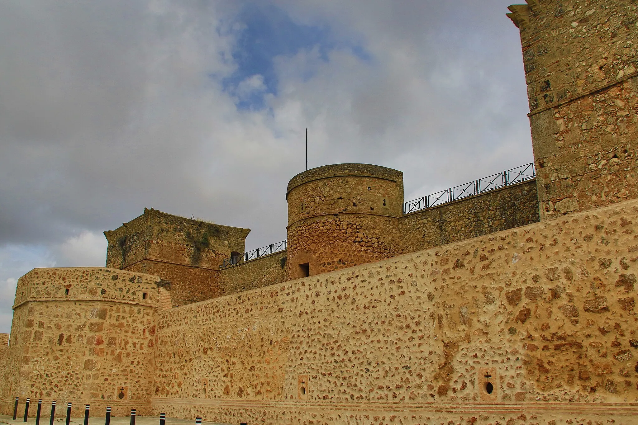 Photo showing: El castillo de Niebla (o de los Guzmanes) es una fortificación histórica situada en el municipio español de Niebla (Huelva, Andalucía). El edificio, situado en un extremo de la ciudadela construida durante la taifa de Niebla, tiene planta cuadrangular, dividida en dos grandes patios rodeados de torreones cuadrados. La torre del homenaje se levanta en la esquina nordeste y tiene planta cuadrada rematada por almenas defensivas. El material empleado en la construcción mezcla el aparejo de sillarejo, los sillares de piedra y el tapial.
Aunque el castillo tiene restos romanos, visigodos y andalusíes, la construcción del edificio actual es posterior a la Reconquista y a la creación del condado de Niebla, siendo el II duque de Medina Sidonia el constructor del castillo actual. El terremoto de 1755 provocó graves desperfectos tanto en las murallas como en el castillo, pero principalmente en la torre del homenaje. Durante la Guerra de la Independencia, parte de las murallas y el castillo fueron destruidos por las tropas francesas.