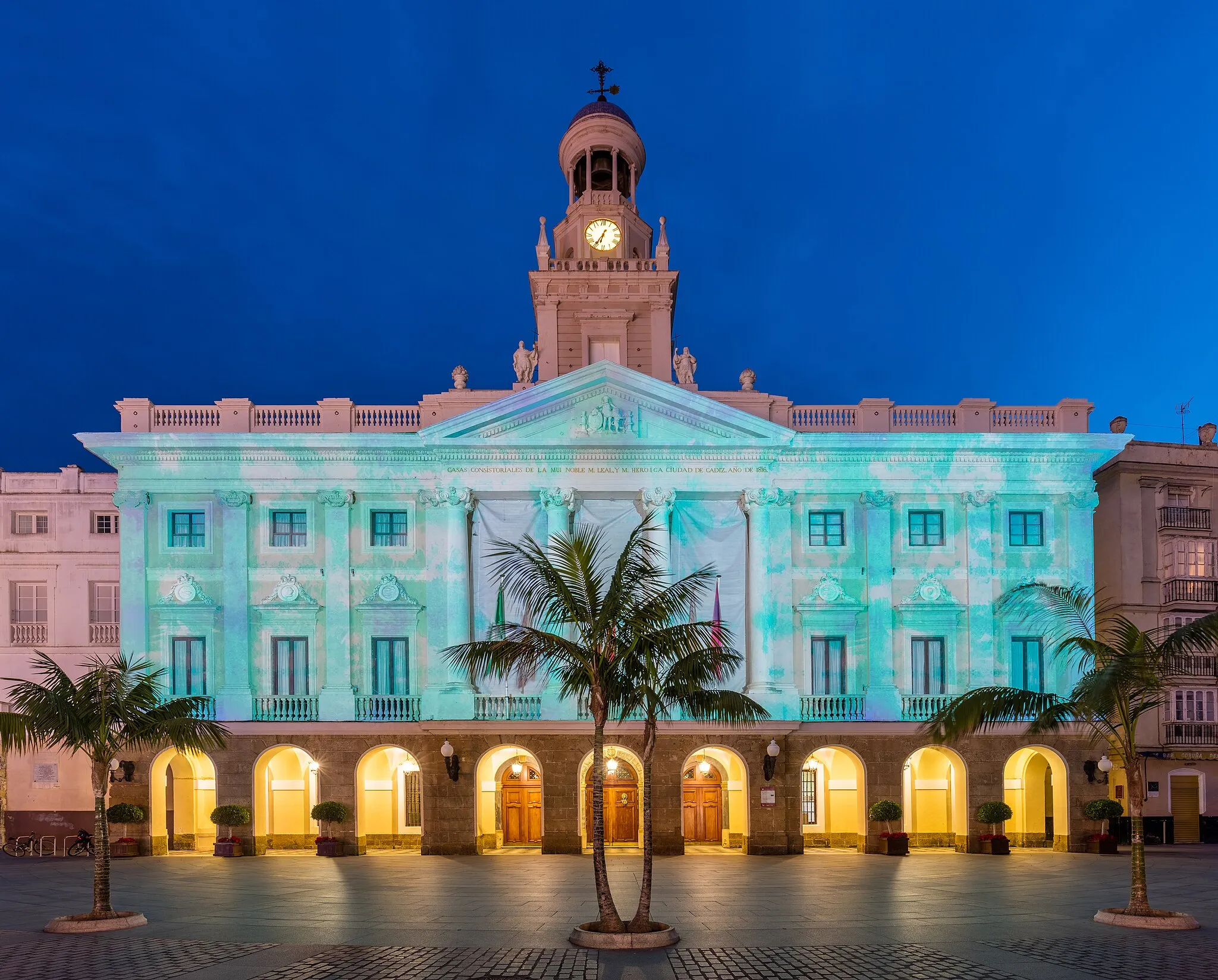 Photo showing: Night view with Christmas patterns of the facade of the town hall of Cádiz, Andalusia, Spain. The building was built in 1799 over the former town hall building and is the result of 2 different stages: the first one, Neoclassical, started in 1799 by Torcuato Benjumeda, and a second one of Isabelline style, work of García del Álamo in 1861.