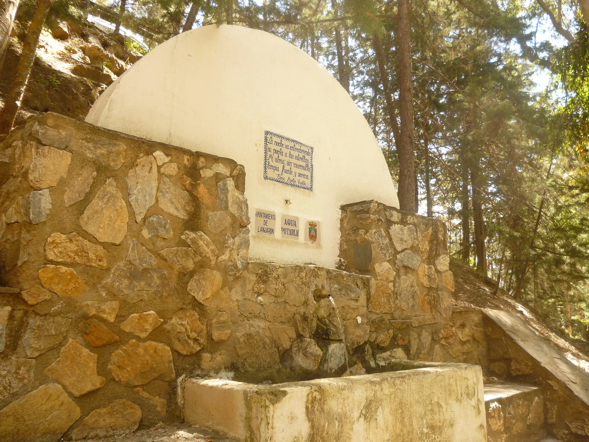 Photo showing: Fuente de agua en el parque El Salado, Lanjarón.
Texto en la fuente:
La noche va entreabriendo
su puerta a las estrellas.
Mi alma, sin murmullo,
limpia fuente y serena.

--Elena Martín Vivaldi