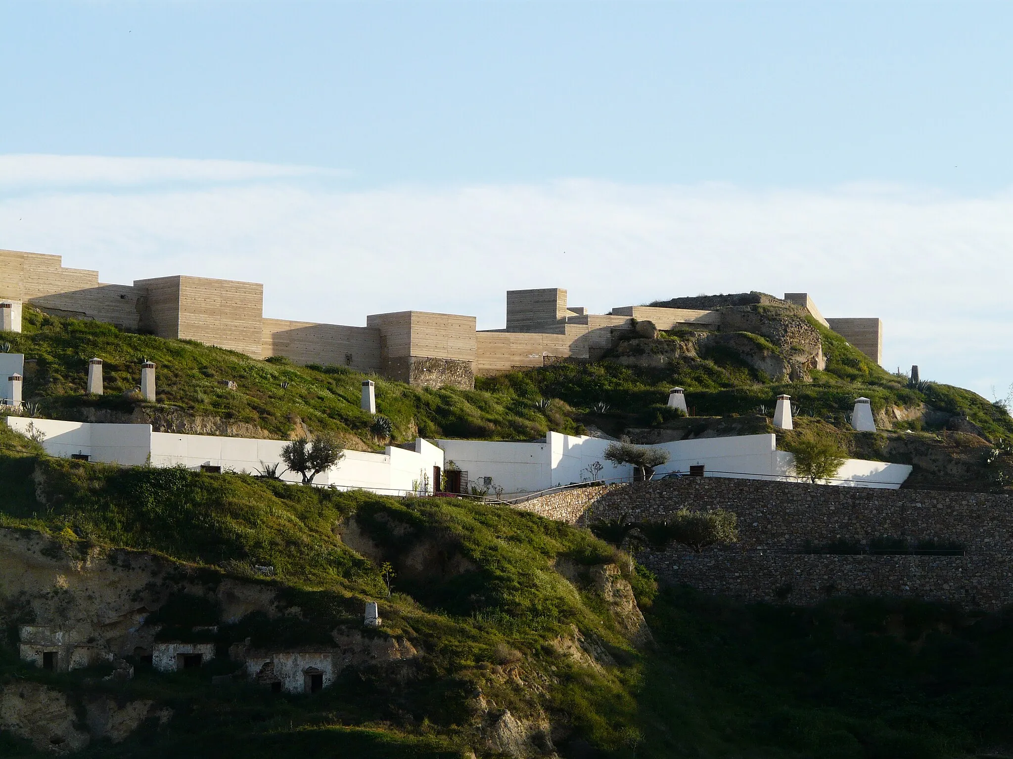 Photo showing: En primer plano se ven las casas cuevas tematizadas y en la cima del cerro el Castillo de Nogalte