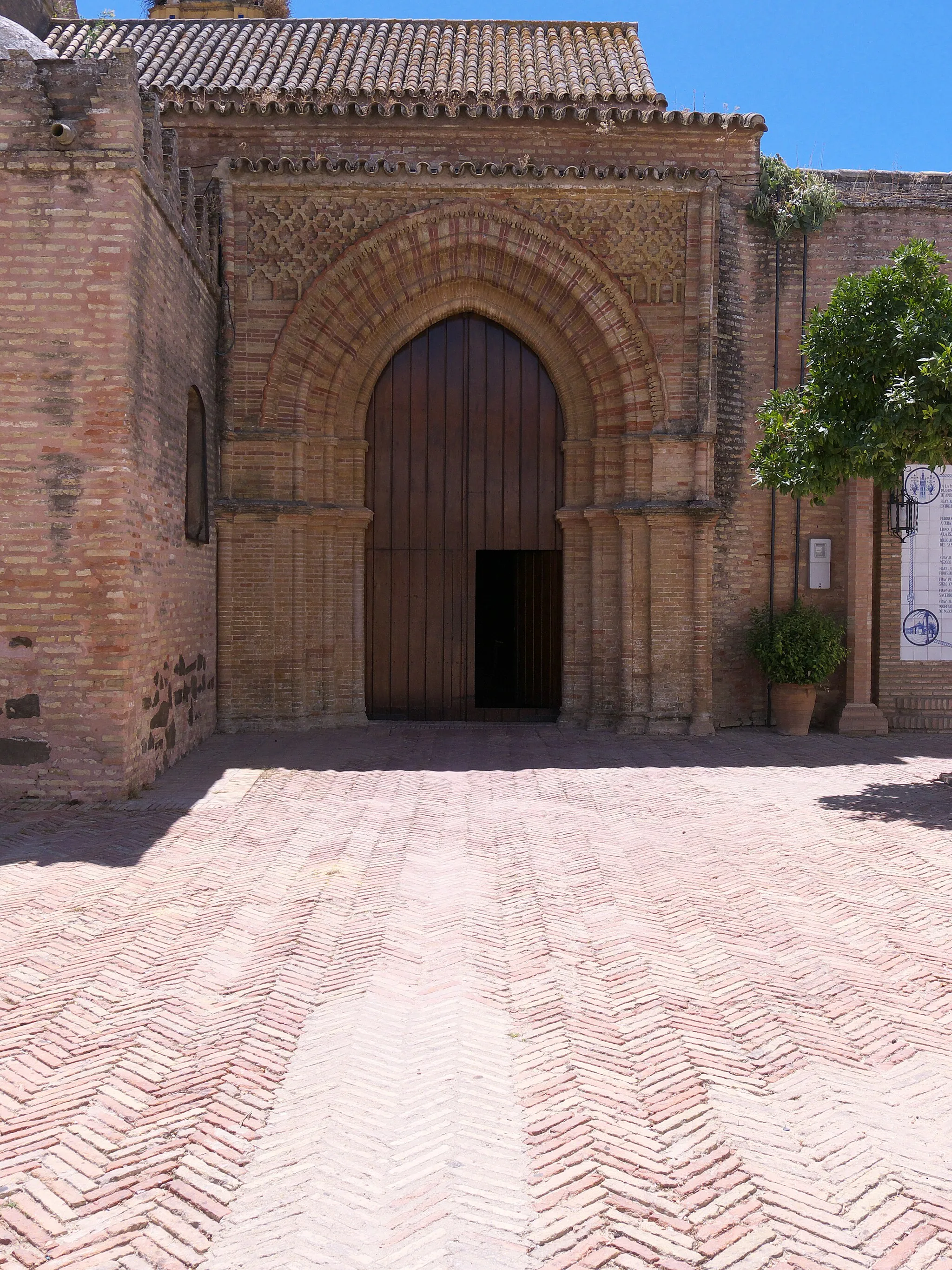 Photo showing: Puerta septentrional. Obra importante en la arquitectura mudéjar (s. XV), de ascendencia almohade, magnífico trabajo con ladrillos de distinto color. Históricamente, por esta puerta salieron los marineros (3 de agosto de 1492) para embarcarse en el primer viaje de Colón.