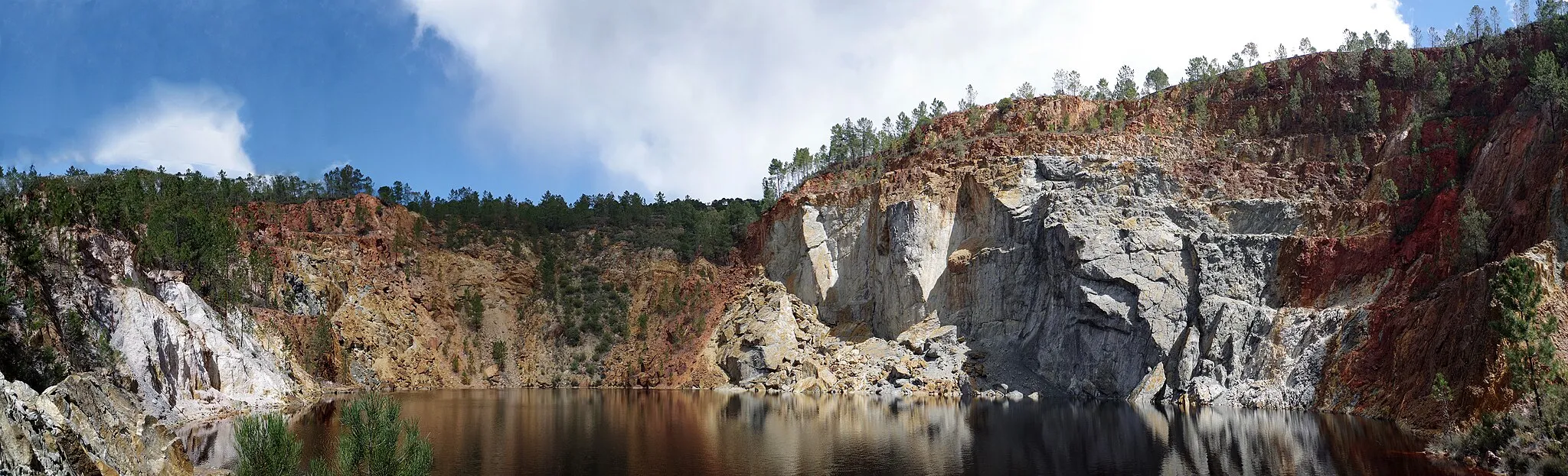 Photo showing: "Peña del Hierro" mine in Nerva. (Huelva, Spain). Kaolinite, white; goethite, red; and sulfates, grey.