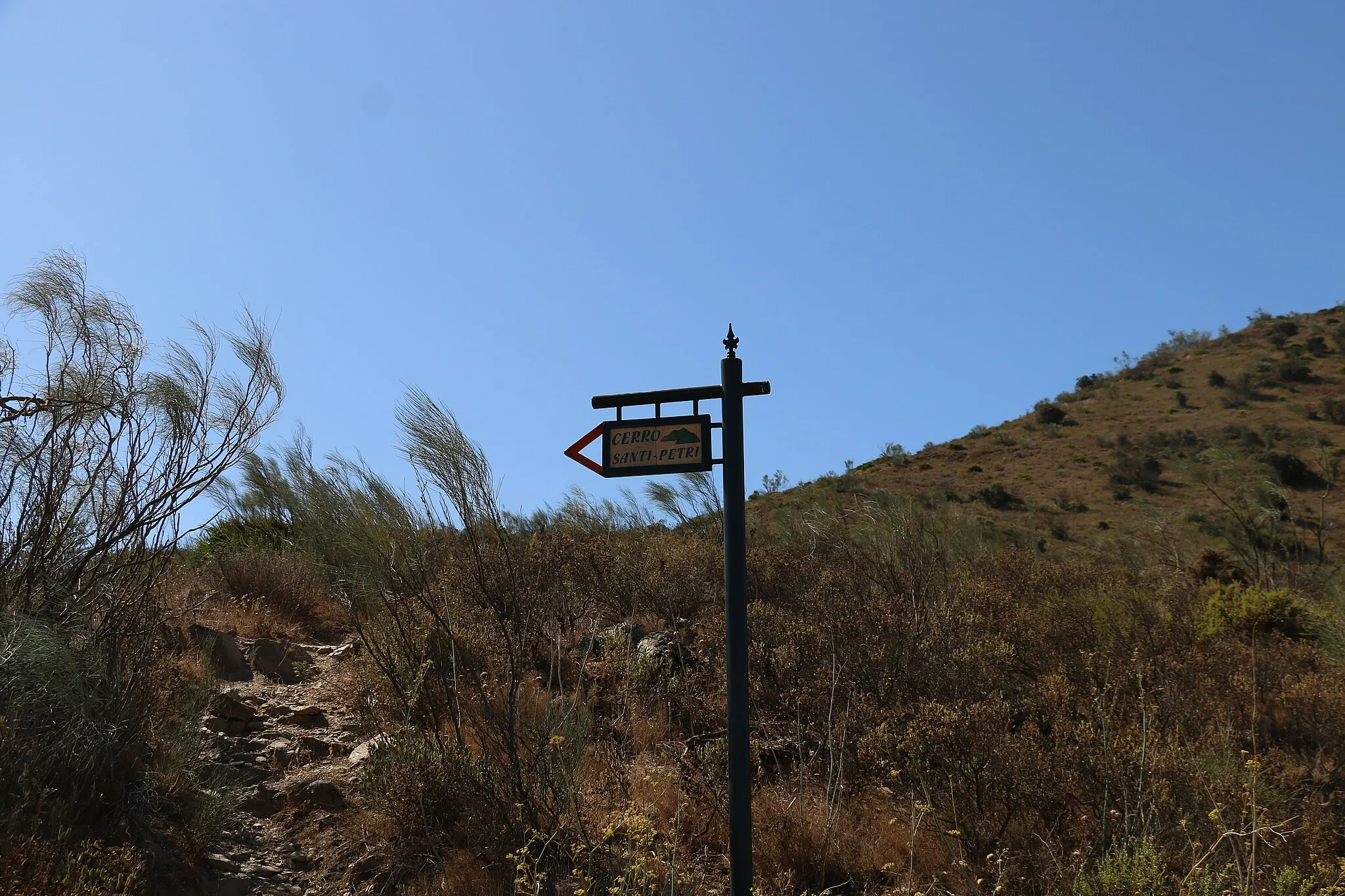 Photo showing: Cartel que indica por dónde se accede a la cima de este cerro. Cerro de Santi Petri. Es la parte más alta y dónde estaba situado el Castillo y donde aún quedan algunos restos mínimos del muro o murallas del castillo.