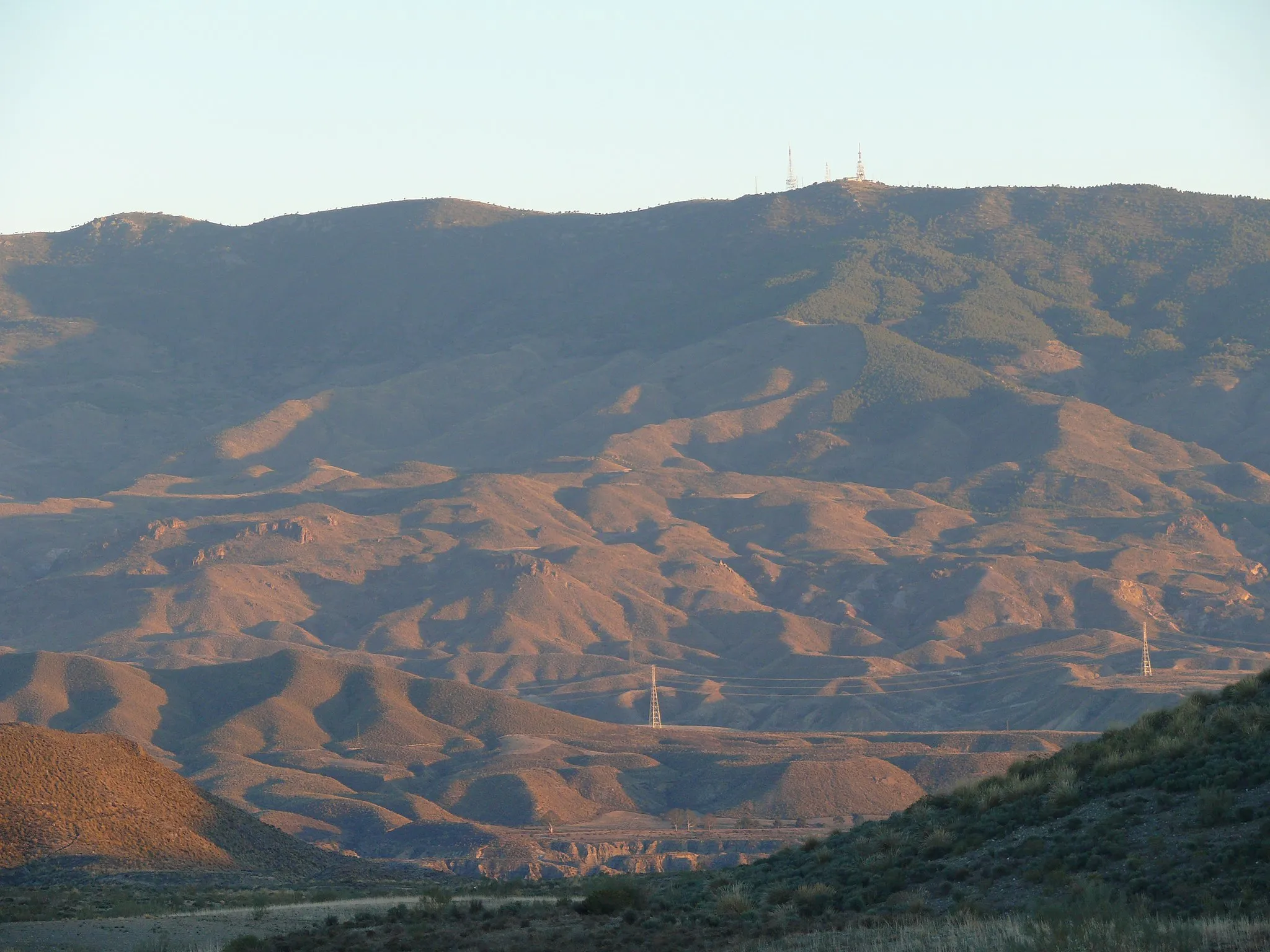 Photo showing: Cara norte de Sierra Alhamilla tomada desde Tabernas. Se aprecia el bosque de encinas y el pico El Puntal con sus antenas