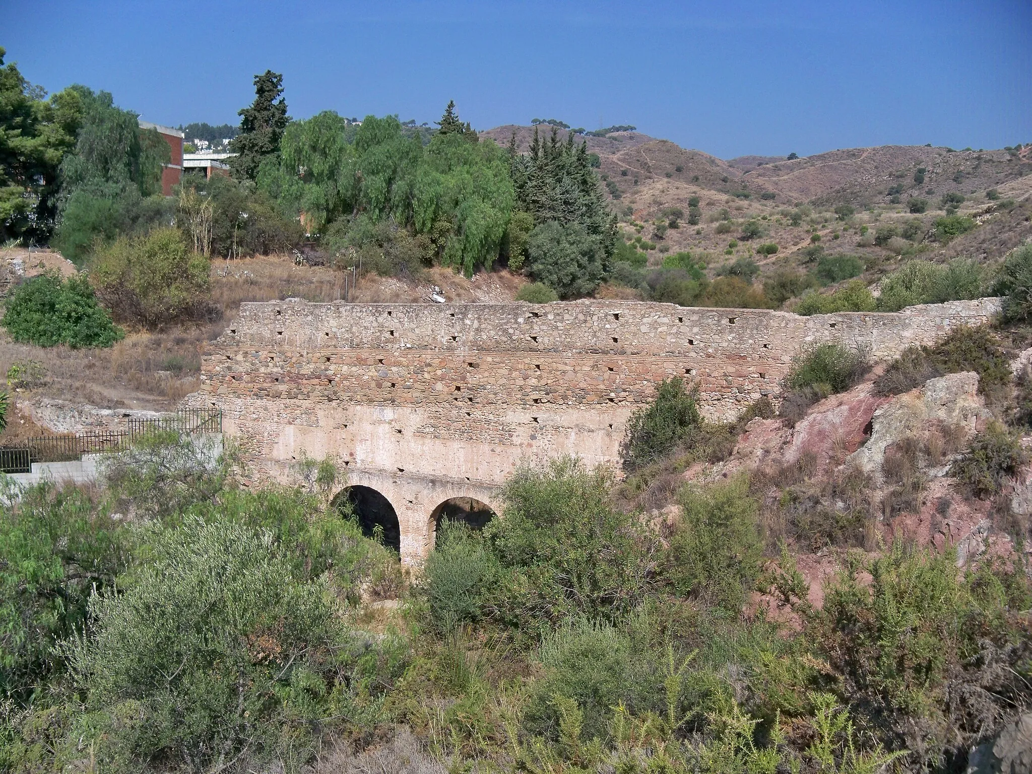 Photo showing: Acueducto de Torre Atalaya, en Málaga, España. Del acueducto se conserva el puente que se observa en la imagen, un puente que discurre sobre el arroyo de Teatinos y que conducía agua desde un manantial en Torre Atalaya hasta el acueducto del Almendral del Rey (1532-1556), cuyo punto de arranque se encontraba unos metros aguas a bajo, en las minas del Almendral del Rey. Este acueducto formaba parte del sistema de abastecimiento de agua de la ciudad de Málaga conocido como Aguas de la Trinidad, que estuvo en funcionamiento desde mediados del siglo XVI hasta principios del siglo XX.