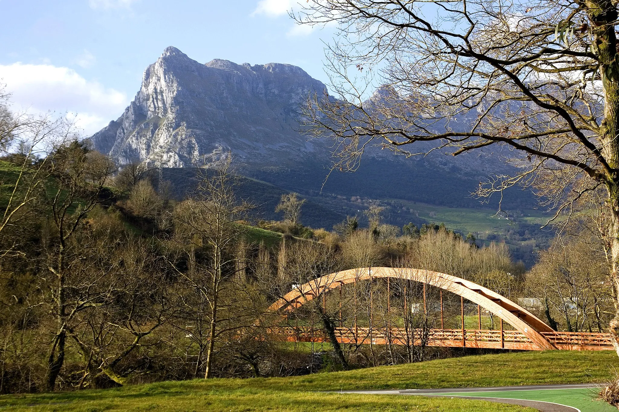 Photo showing: Vistas del Pico de San Vicente y puente de madera sobre el río Asón desde el parque de Cubillas de https://www.ramalesdelavictoria.com