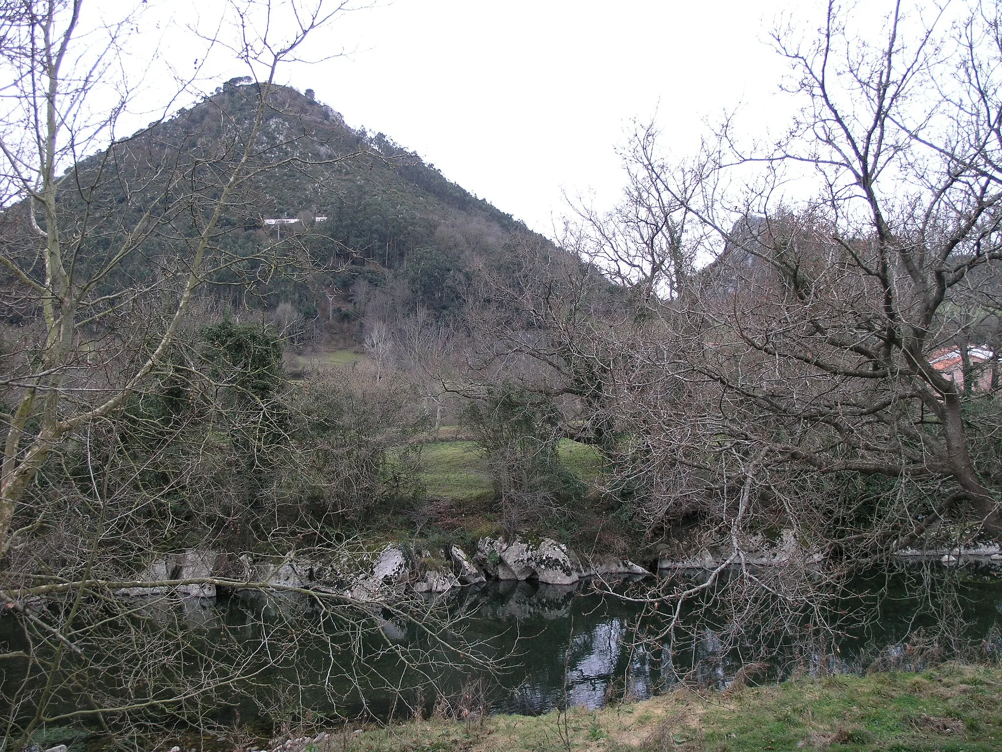Photo showing: Monte o Pico Castillo (355 m), con el río Pas en primer término, en cuyas laderas se encuentran las cuevas de Puente Viesgo. Se puede subir desde Puente Viesgo, a través del PR-S.17.