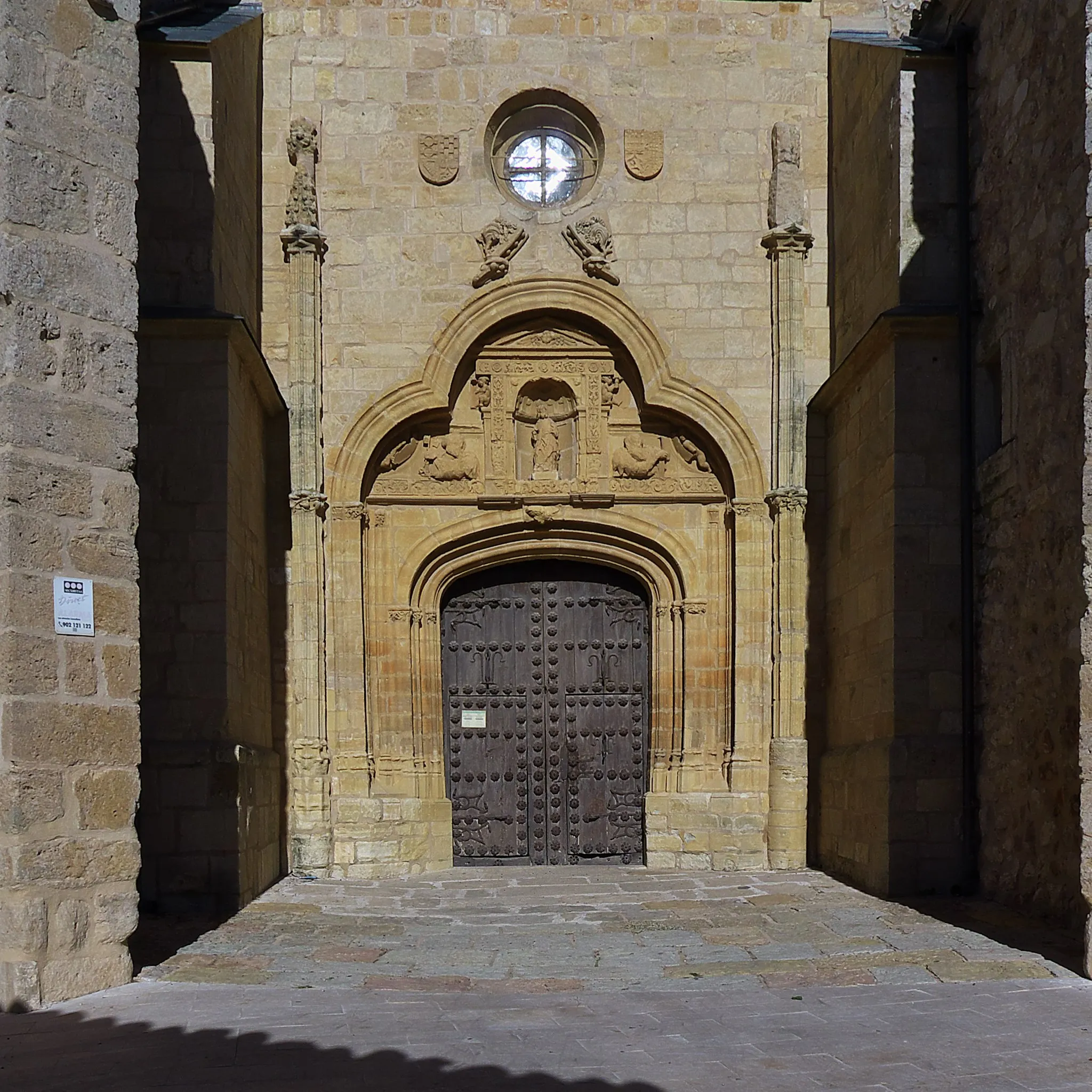 Photo showing: Portada meridional de la iglesia, con los escudos del Marquesado de Villena. A principios del siglo XVI se le añadió un tímpano plateresco.