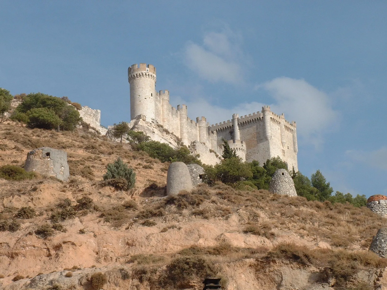 Photo showing: Castillo de Peñafiel, Peñafiel Castle, Valladolid, Spain. Viewed from NW. The vents in the foreground are for the ventilation of underground caves used as wine cellars because they keep constant low temperature all around the year.