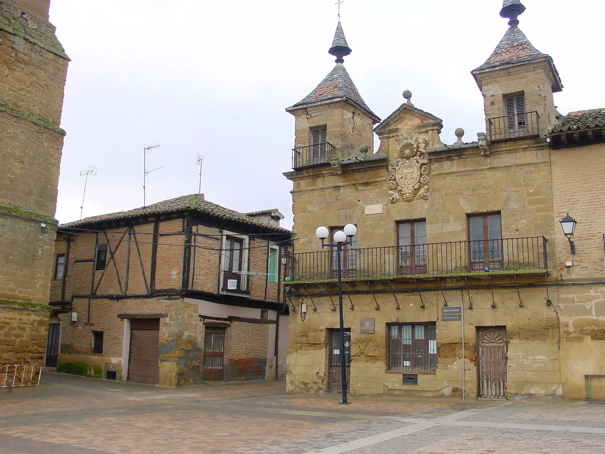 Photo showing: Valderas (León, España). Edificio de correos. Es la antigua casa consistorial. Está situado en la plaza Mayor. Fue edificado sobre el solar donde se supone que estaba la casa de María de Zarzas. Data de 1701 y su estilo es herreriano, con dos torrecillas en los costados, con sendos balcones, rematadas por chapiteles que terminan en estípites. A la izquierda puede verse la casa más antigua de la villa.

Autor de la imagen: Lourdes Cardenal, enero 2006.