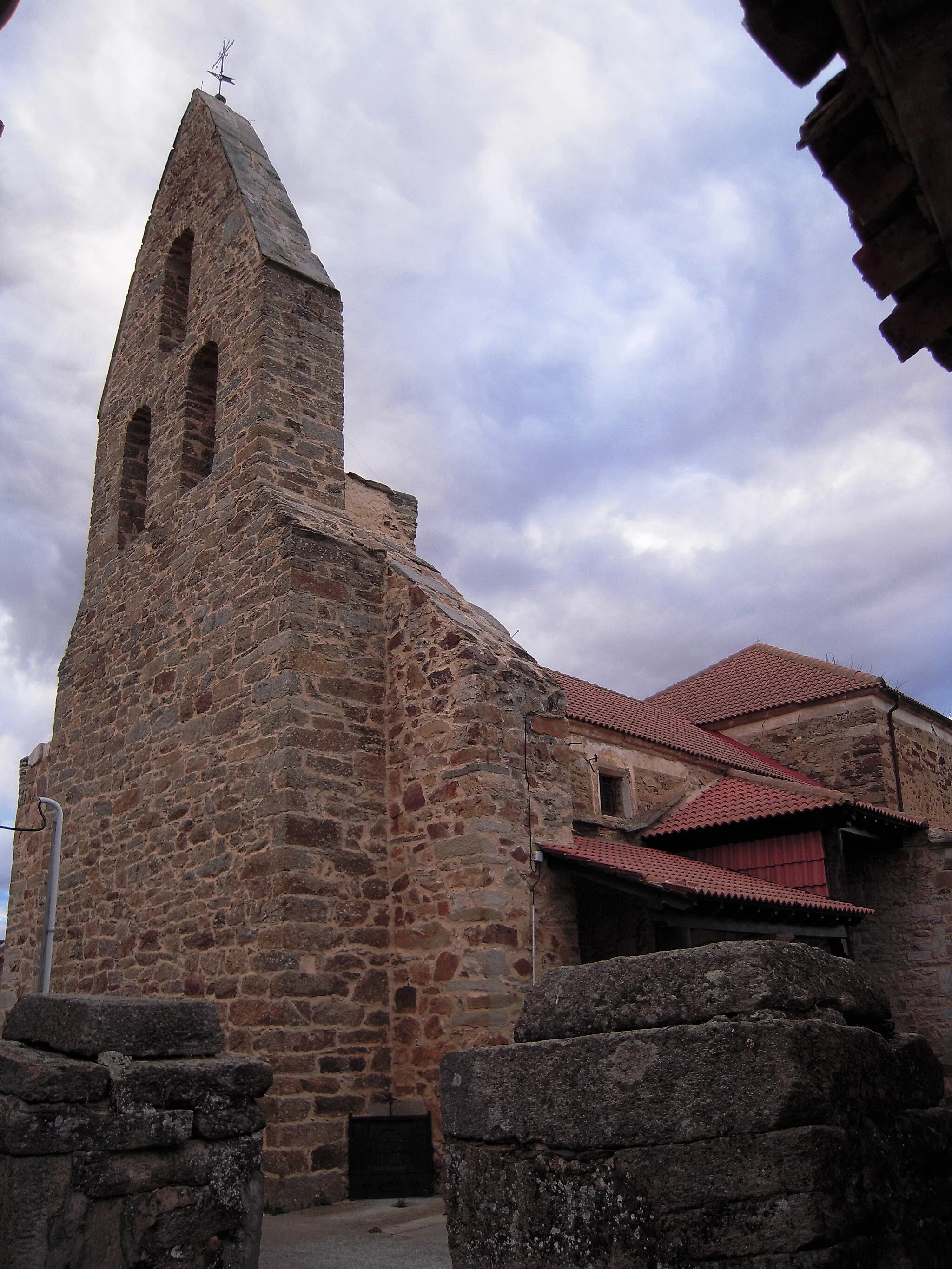 Photo showing: Exterior de la Iglesia parroquial de Sitrama de Tera, dedicada a San Miguel. Es una mezcla de varios estilos. La portada es gótica tardía, de comienzos del siglo XVI,​ con un arco de medio punto decorado con roscas de bolas. Un gran arco gótico sirve de divisorio entre el presbiterio y la nave.