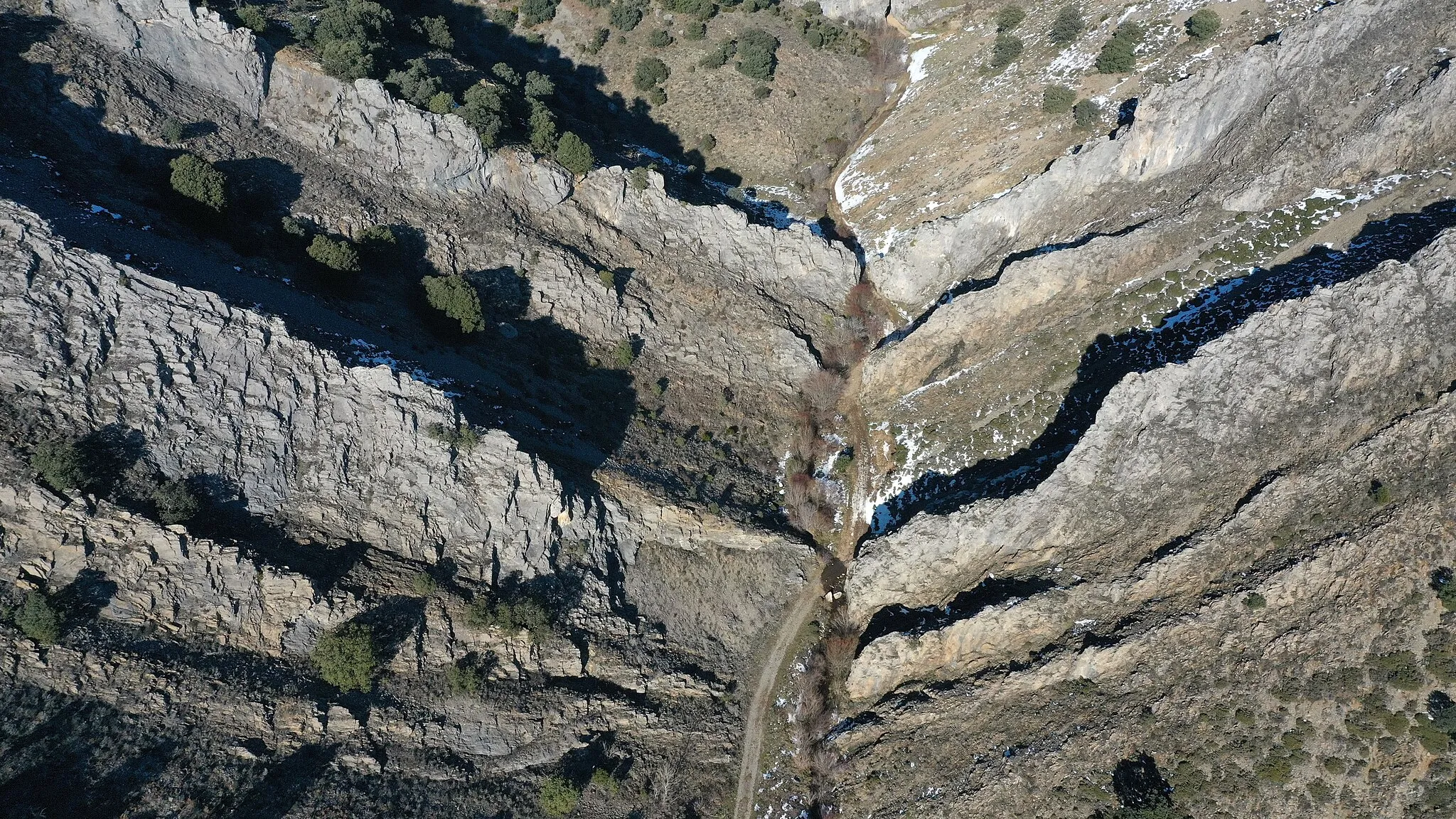 Photo showing: Vista aérea del corte erosionado por el arroyo de San Martín en las calizas de la formación Barcaliente (Carbonífero) —calizas micríticas y microesparíticas negras y fétidas— en Olleros de Alba, La Robla, León