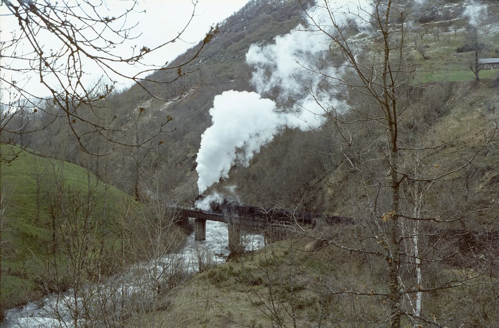 Photo showing: Un train franchit la rivière Sil vers Robles de Laciana au mois d'avril 1983.