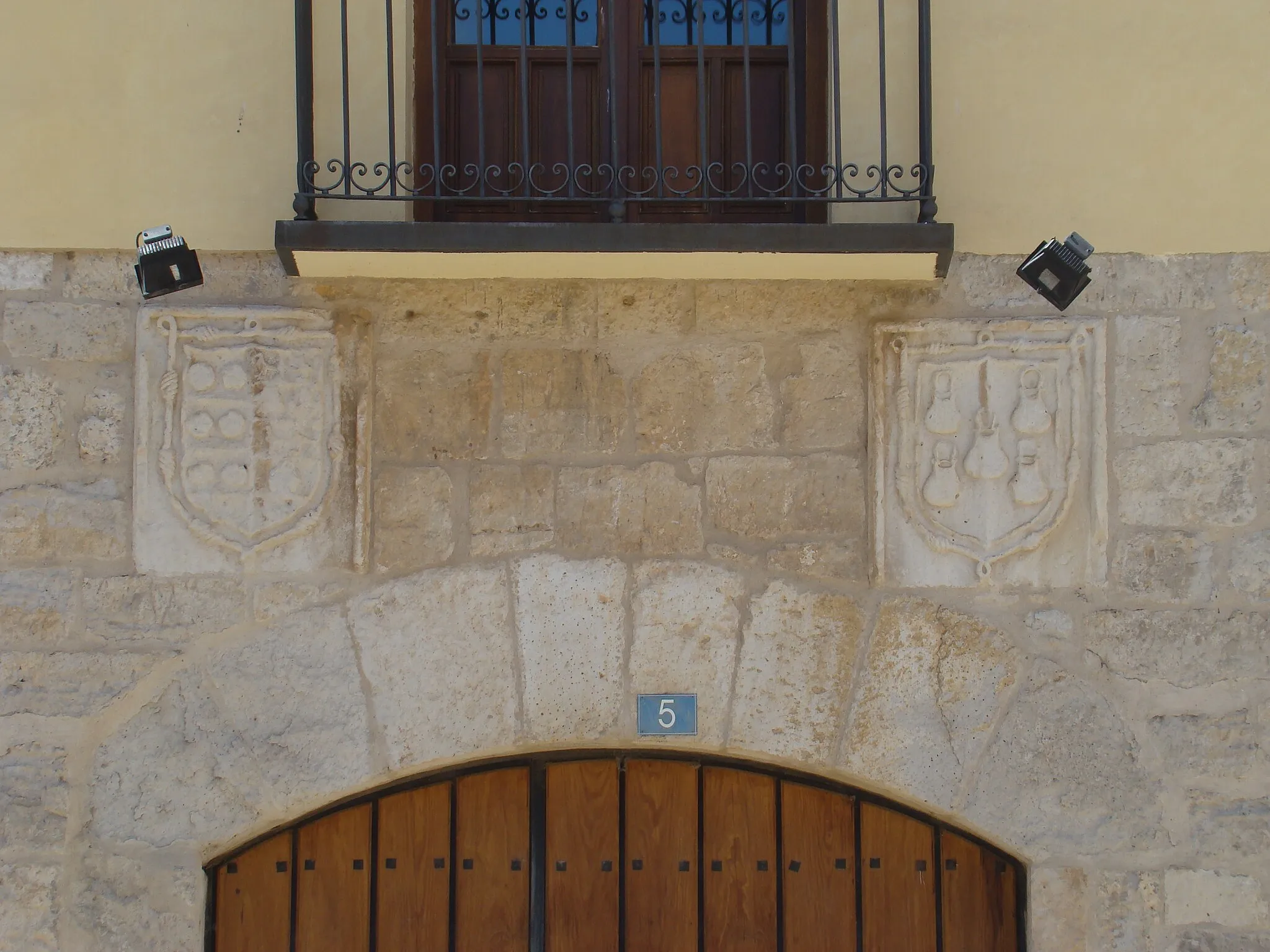 Photo showing: Casa Calderón Castro.
Situada en la Calle Corro Vaca nº 5 de Cigales, Valladolid. Es la antigua casa de D. Francisco Calderón, mayordomo de los Duques de Frías. Construida entre finales del siglo XV y principios del XVI sobre zócalo de piedra. Tiene dos pisos. La portada es de piedra caliza y tiene un arco escarzado con grandes dovelas. A derecha e izquierda están labrados los escudos de los Calderón y los Castros. La casa sirve de sede para el Consejo Regulador de la Denominación de Origen de Cigales.