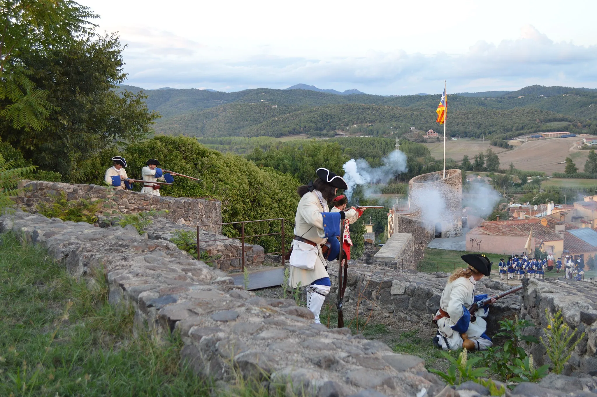 Photo showing: Miquelets de Girona – Regiment de Sant Narcís. El dissabte,  faran la III recreació històrica Hostalric, Baluard Austriacista. 
La plaça d'Hostalric va ser una fortificació important de Carles III i l'Aliança. Un dels objectius de l'Expedició del Diputat Militar era evitar la seva caiguda a mans borbòniques. La missió va fracassar i el 17 d'agost es lliurava la plaça al borbònic Francesco Marulli; mentre l'expedició es dirigia cap a Arbúcies.