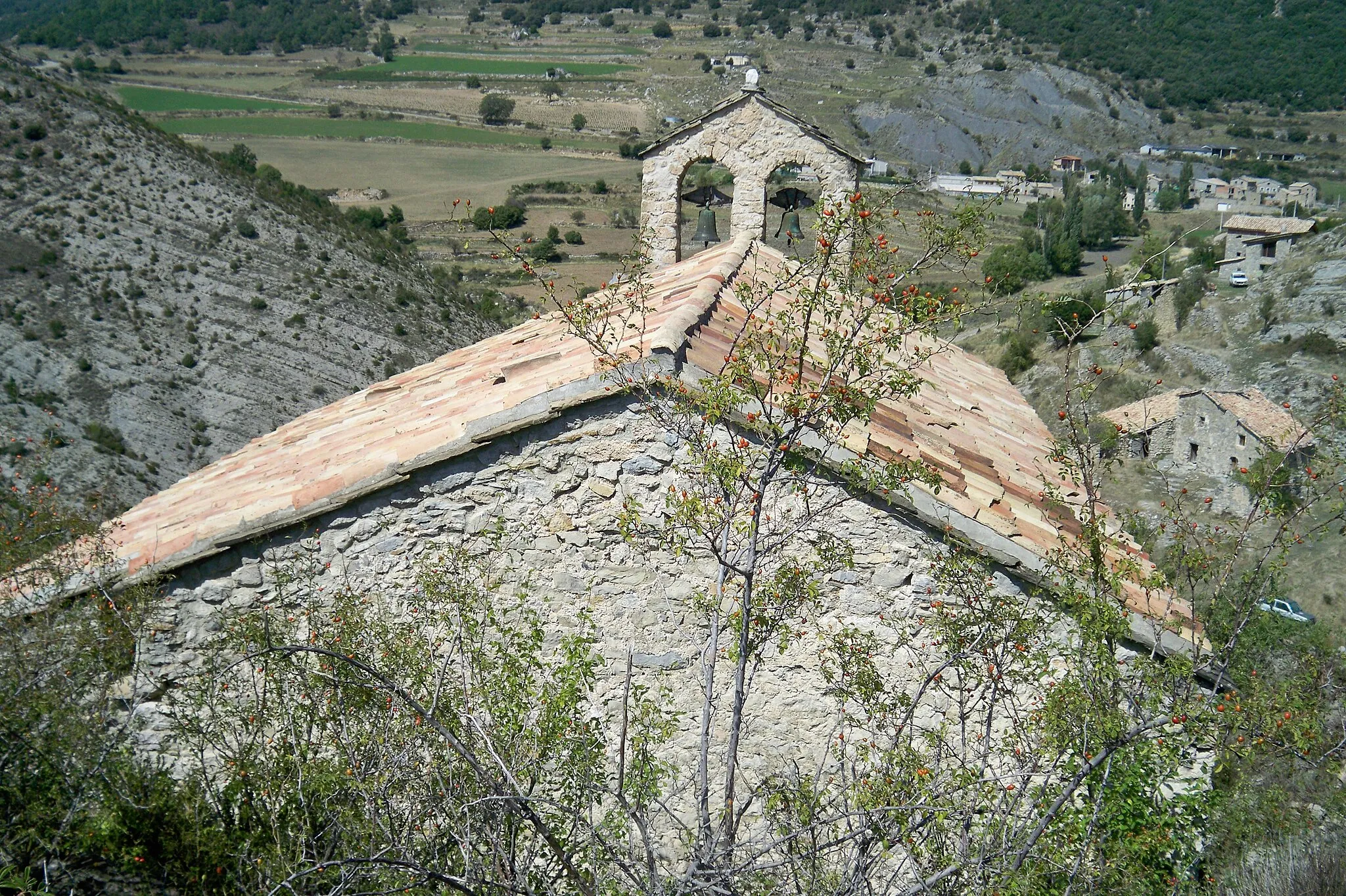 Photo showing: Vista de la façana Sud de l'església de la Mare de Déu de la Salut de Montanissell on s'observa la teulada a dos vessants i el campanar situat sobre la façana nord.