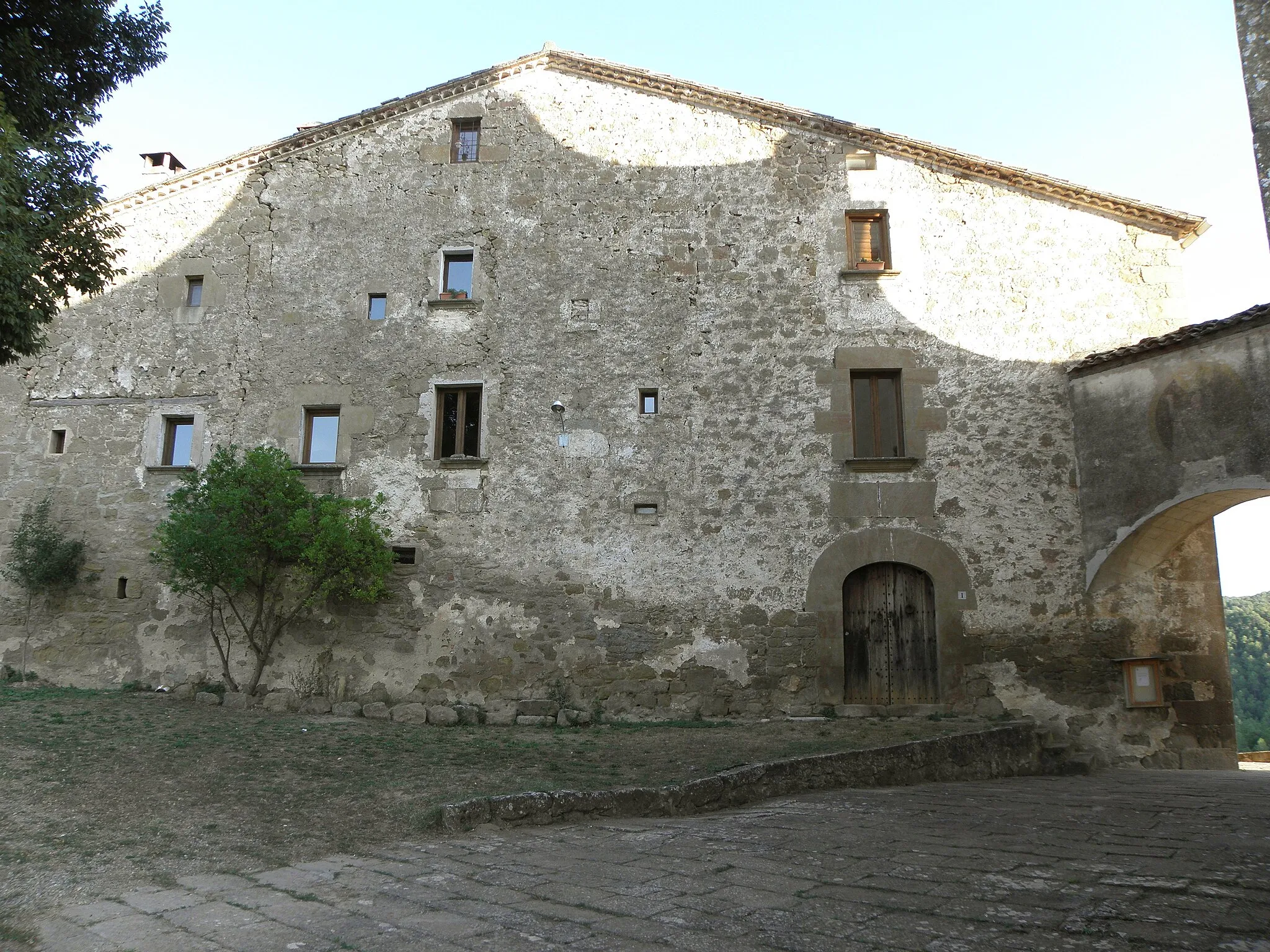 Photo showing: La façana nord-occidental de la rectoria de Madrona (Pinell de Solsonès). A la dreta, el pont que comunica la rectoria amb la nova església.