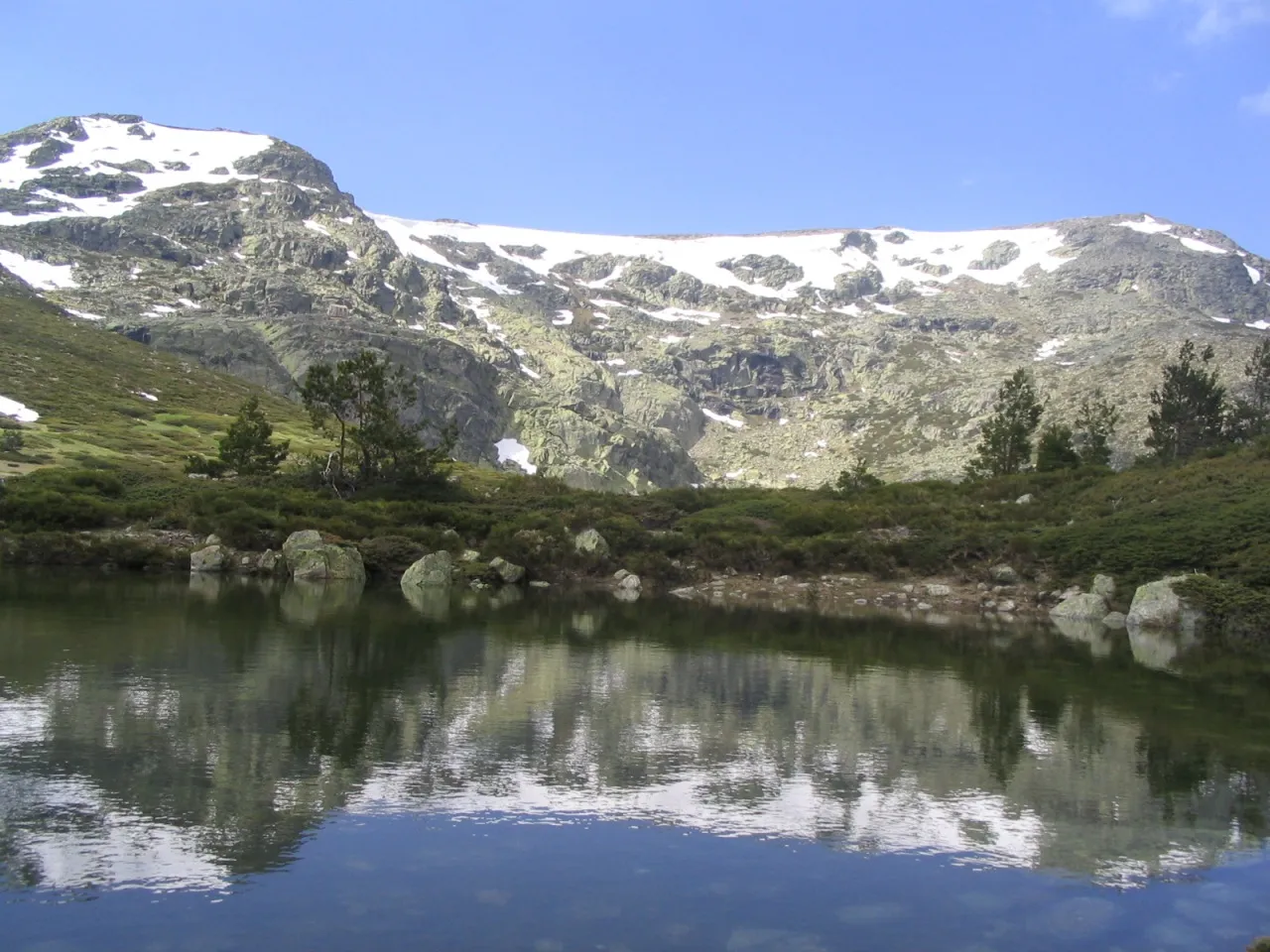 Photo showing: View of the circus of Peñalara and its reflection in the Small Lake (2,005 ms). As much this circus as the lake is of origin glacier, like more than twenty small lakes that sprinkle the Natural Reserve of Peñalara. This circus glacier is one of the formation more important glaciers of the Sierra de Guadarrama and the Central System (mountain range to which the Mountain range of Guadarrama belongs). In the superior end straight of the image it appears the summit of Peñalara, the highest mountain of the Mountain range of Guadarrama with his 2,430 meters of altitude. This mountain range is in the center of Spain.