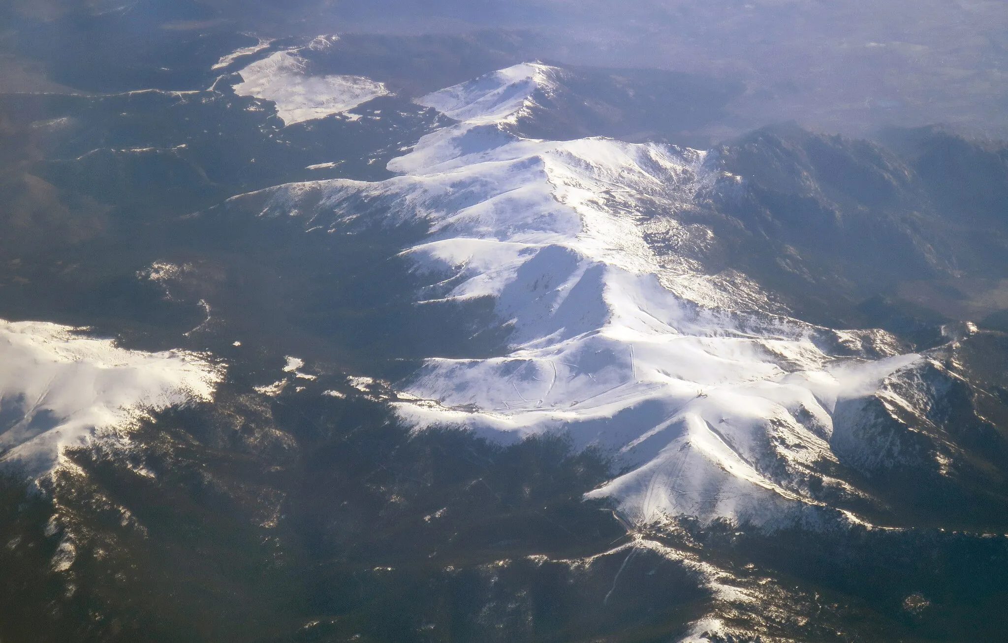 Photo showing: An aerial view of the Cuerda Larga, which is a branch of the Sierra de Guadarrama mountain range near Madrid. The nearest peak is Bola del Mundo.