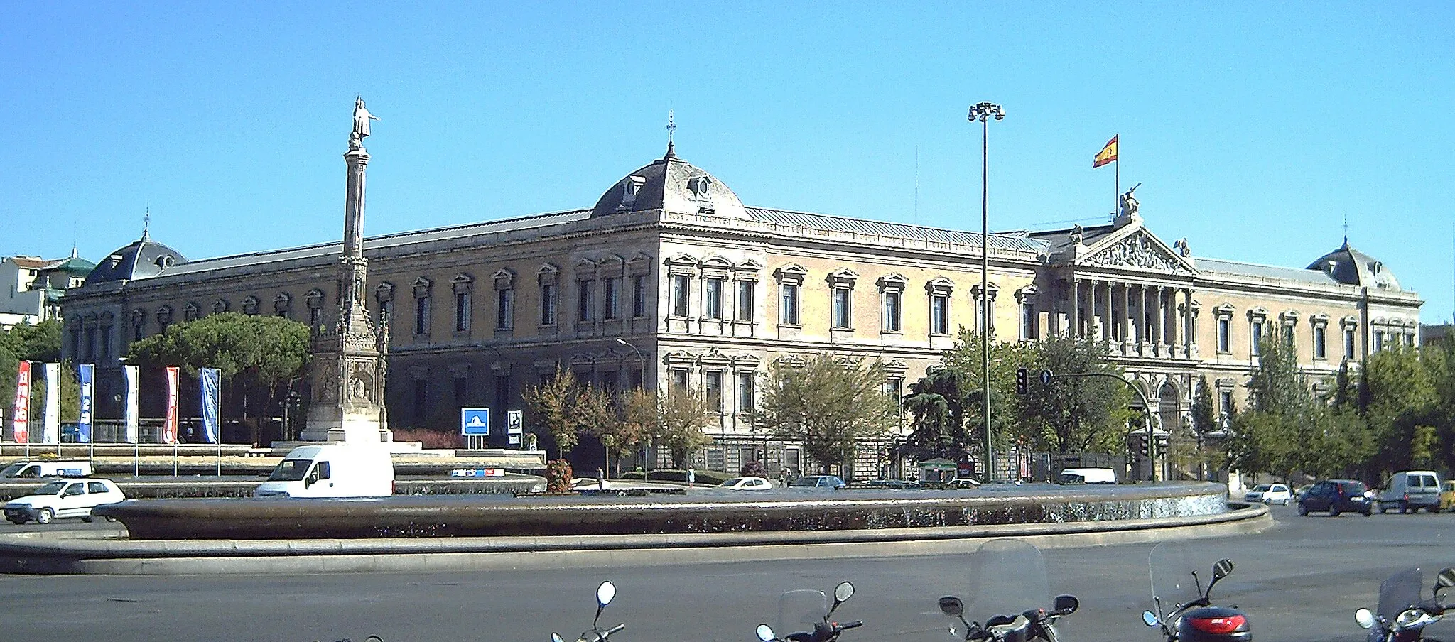 Photo showing: View of the façade of the National Library of Spain, in Madrid. On the back, there is the National Archaeological Museum. The image was taken from the Plaza de Colón ("Columbus Square"). The building was projected by architect Francisco Jareño (1818–1892) and built between 1866 and 1892. The column before the building is the monument to Columbus (inaugurated in 1892).