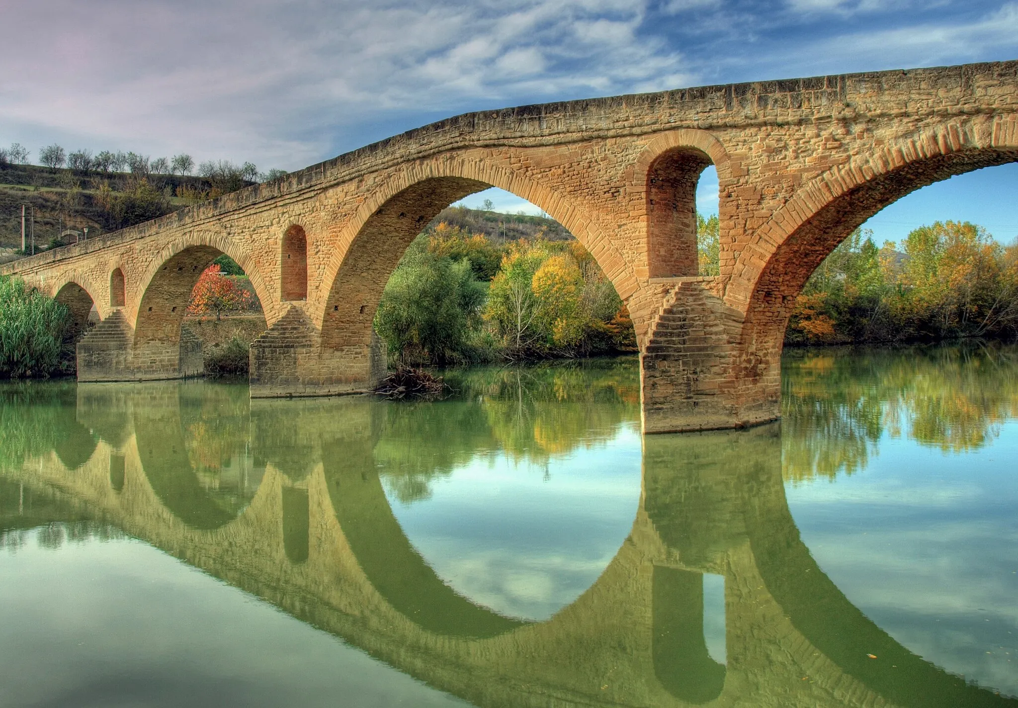 Photo showing: Puente la Reina (Gares, cooficialmente en euskera) es una villa situada en la Comunidad Foral de Navarra (España), en la merindad de Pamplona, a 24 km de la capital de esta comunidad (Pamplona) y en la comarca de Valdizarbe. Esta villa es un punto muy importante en el camino de Santiago. La tradición dice que el nombre de Puente la Reina proviene del puente románico sobre el río Arga, que fue mandado construir en el siglo XI por una anónima reina de Navarra. Generalmente se hace referencia a que esta reina fue Doña Mayor, esposa de Sancho el Mayor o Doña Estefanía, mujer de García el de Nájera.