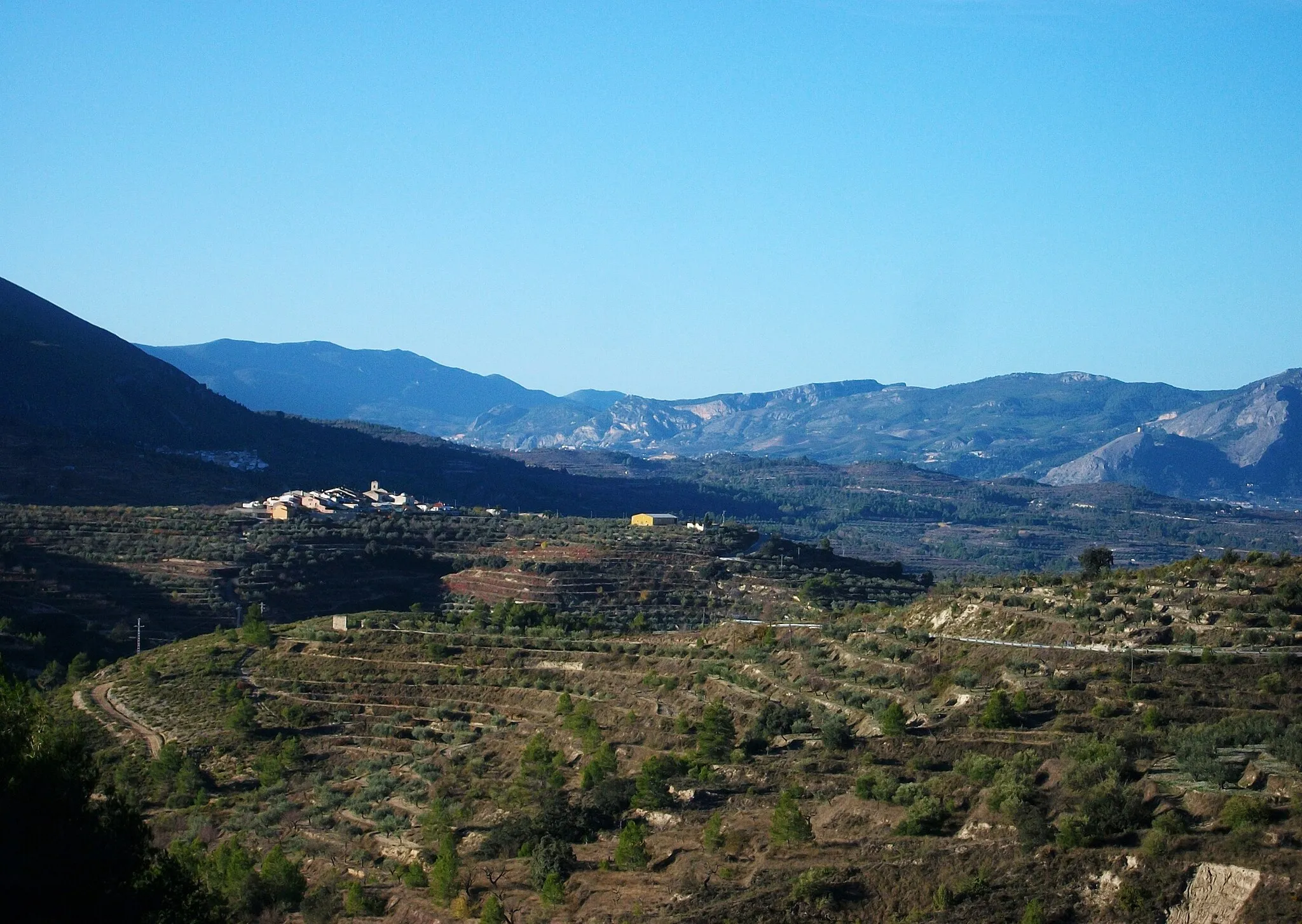 Photo showing: El nucli de Catamarruc, peratnyent al municipi de Planes, al fons a l'esquerra Almudaina, el Comtat. Al fons a la dreta s'aprecia el castell de Cocentaina.