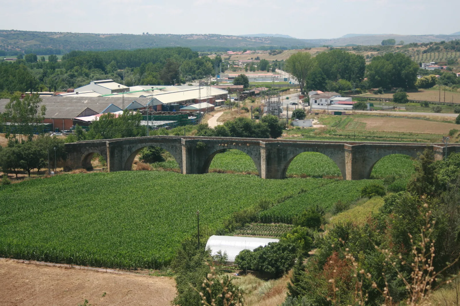 Photo showing: Coria old bridge. The river has changed course, and no longer flows beneath the bridge. Instead there are fields of green crops